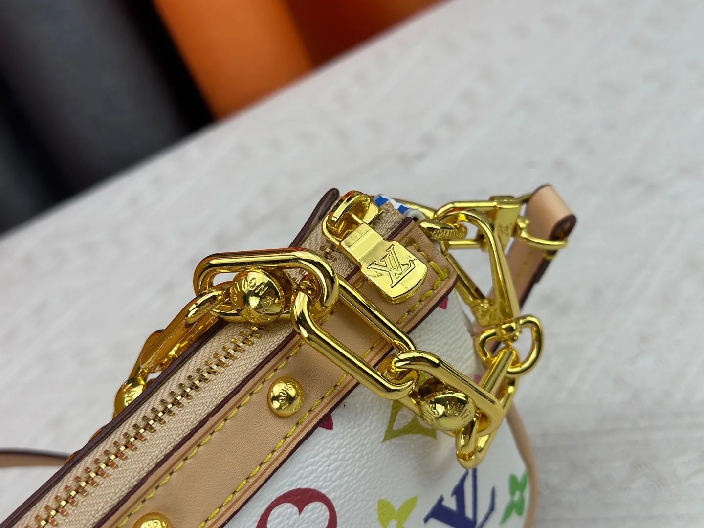 P220 M13404 M13663 Black color White color This Pochette Accessoires handbag is made of coated canvas, with colorful Monogram patterns to interpret the smart style of the Louis Vuitton × Murakami cross-border collaboration series. Calf leather trim and dazzling hardware add to the sophisticated details, while the detachable shoulder strap and chain provide flexible carry. Size: 22x13x4cm