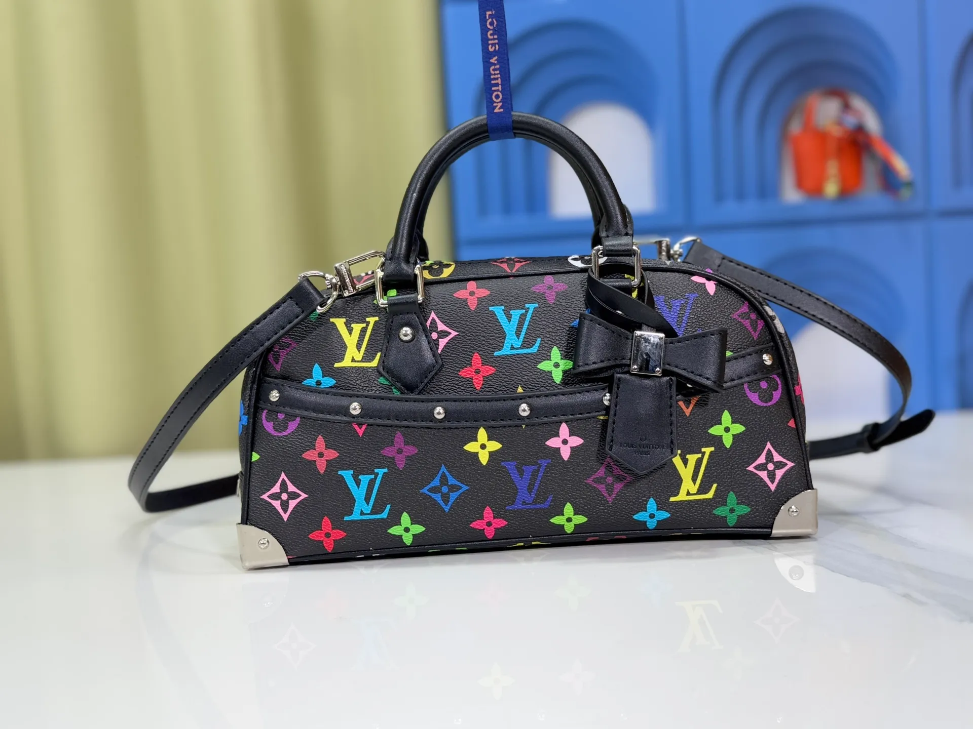 P300 Upgraded Original M13084 This Handbag East West handbag is from the Louis Vuitton x Takashi Murakami reissue series, using the artist's signature rainbow tones to trace the full-length Monogram pattern. Sleek horizontal construction lines the top handle, studded side straps, detachable and adjustable shoulder strap and LV x TM key holder, with cowhide leather details and sophisticated corners that nod to the brand's traditional luggage. Dimensions: 27.0 x 14.0 x 10.0 cm (length x height x width)