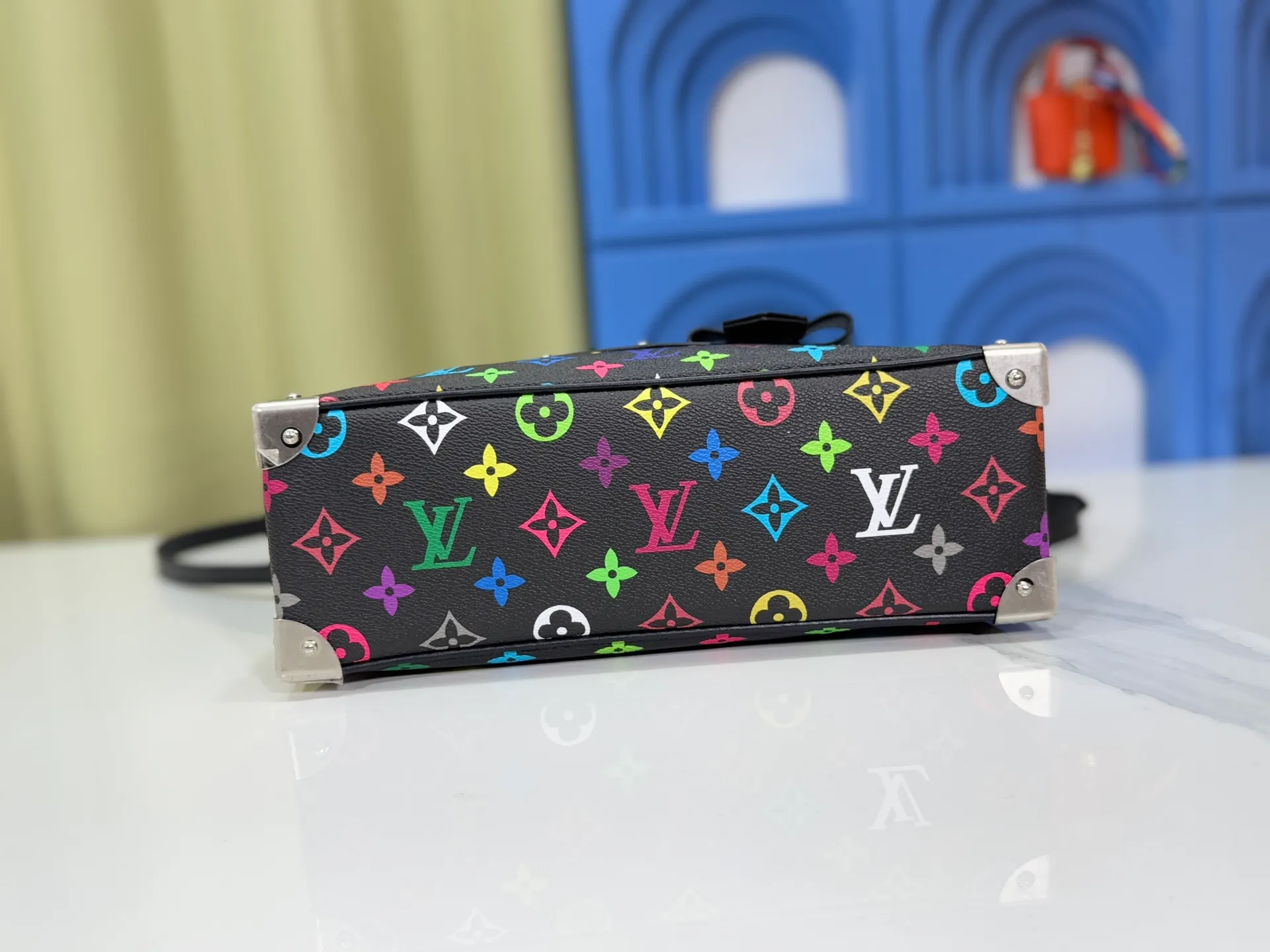 P300 Upgraded Original M13084 This Handbag East West handbag is from the Louis Vuitton x Takashi Murakami reissue series, using the artist's signature rainbow tones to trace the full-length Monogram pattern. Sleek horizontal construction lines the top handle, studded side straps, detachable and adjustable shoulder strap and LV x TM key holder, with cowhide leather details and sophisticated corners that nod to the brand's traditional luggage. Dimensions: 27.0 x 14.0 x 10.0 cm (length x height x width)