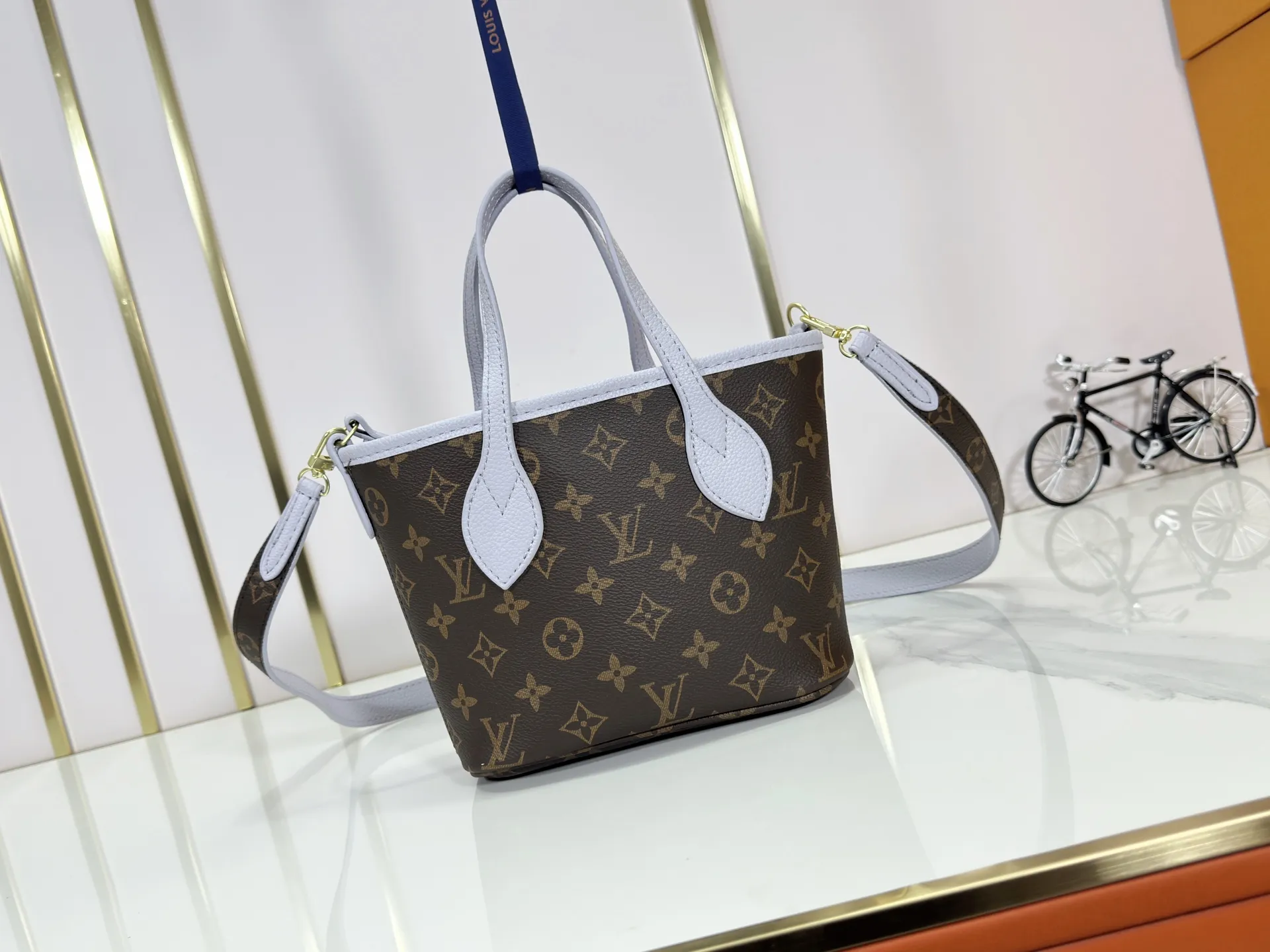 P240 M25656 M12099 Upgraded original Neverfull Bandouliere Inside Out BB handbag is a double-sided version of the classic design this season, with the front and back decorated with iconic Monogram canvas and grained leather. The removable zipper bag can be used alone or hung externally. The detachable shoulder strap makes it easy to wear cross-body, and the dazzling metal hardware adds a sophisticated detail. Dimensions: 26.5 × 16.5 × 11 cm