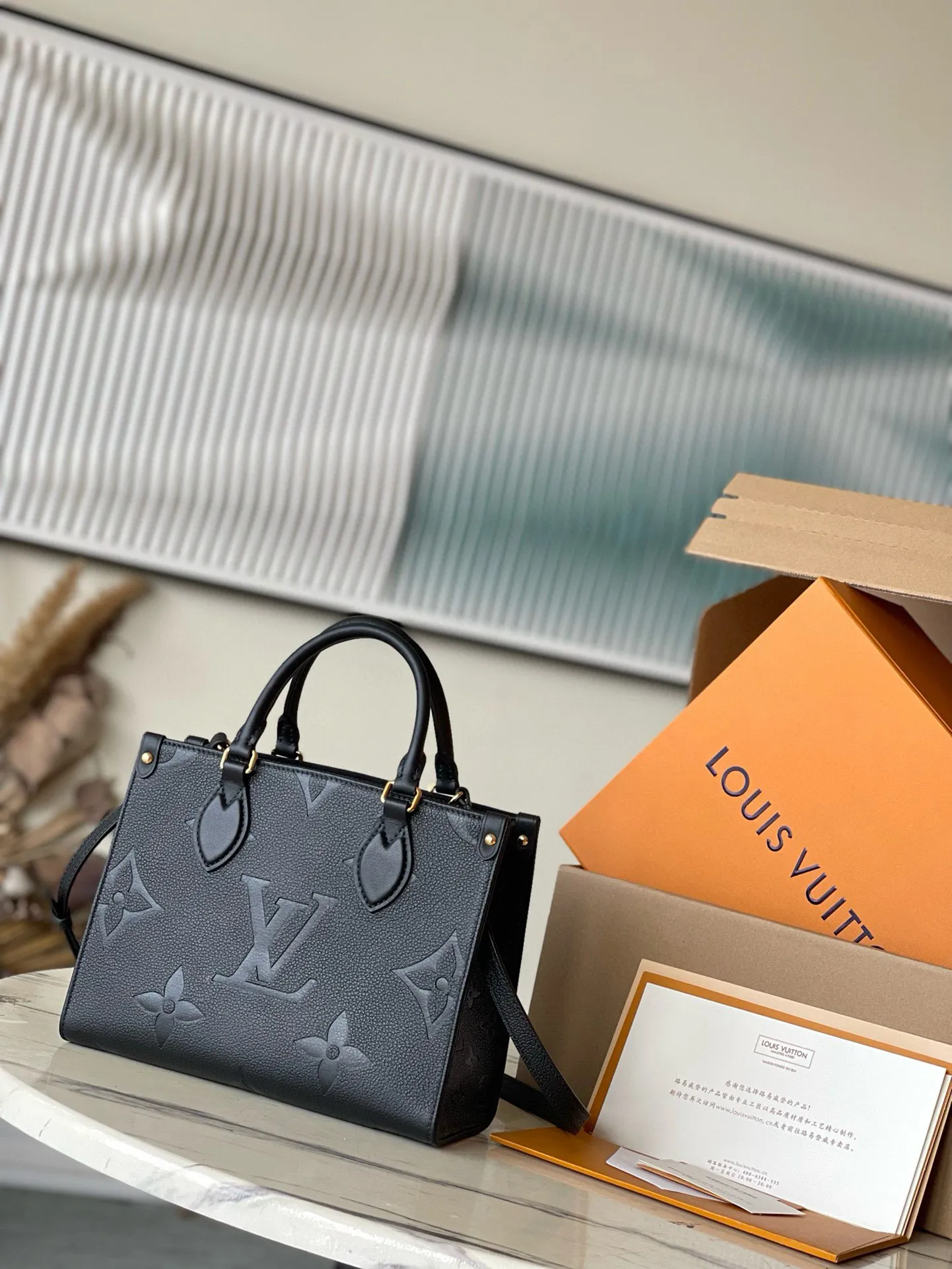 💰1040 (first-grain leather) top original M45653 black printed Onthego small Tote bag draws inspiration from the classic Sac Plat handbag in 1968. It is made of Monogram Empreinte leather with Medium Bicolor Monogram pattern embossed to create a miniature version, which can store daily needs such as iPad Mini. Flexible handles and detachable shoulder strap enrich carrying options. Dimensions: 25 x 19 x 11.5 cm