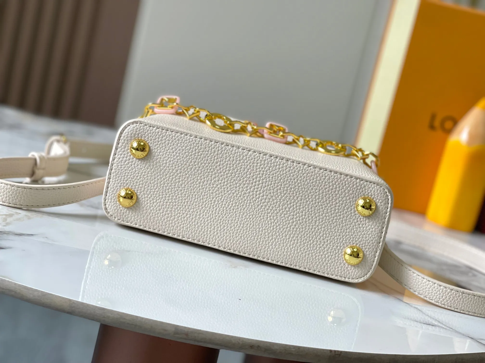 p460 [Guangzhou top quality original] M14393 white CapucinesEastWest mini handbag, with a decorative chain showing the inspiration of Monogram flowers. Taurillon cow leather creates an exquisite structure, and the LV letters interpret the colorful brushstrokes of the Puffygram jewelry series. The flap can be folded in or out, and the inner pocket can safely store valuables. Size:22×12×8cm
