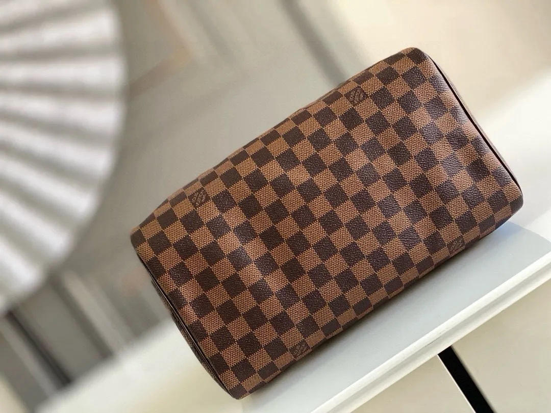 💰760 (strapless model) top original N41364 SPEEDY 30 handbag. Launched in 1930, the Speedy handbag was inspired by the travel revolution at that time and fully displays Louis Vuitton's iconic design style. This uniquely designed and ideal urban handbag is a stylish choice for urban girls. The Speedy 30 bag in Monogram canvas is as elegant as it is practical and durable. Detailed features 30 x 21 x 17 cm (Length x Height x Width) Shiny gold-tone brass hardware Fabric lining Leather trim Handles: Double handle