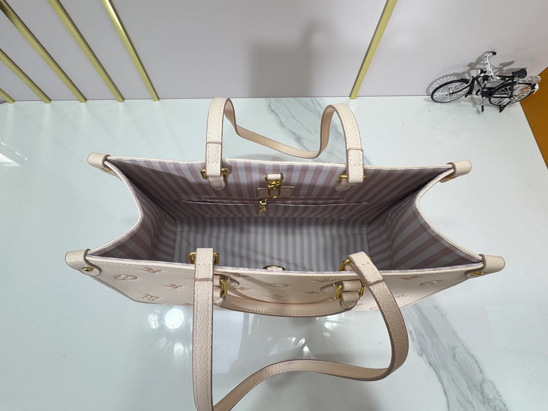 P260 upgrades the original M14403. This OnTheGo small handbag renews the brand's classic Monogram Empreinte leather, using the same tone to outline the pattern. The detachable metal chain accentuates the details, the striped fabric lining adds an elegant touch, and the detachable shoulder strap allows for shoulder or cross-body wear. 35.0 x 27.0 x 14 cm (length x height x width)