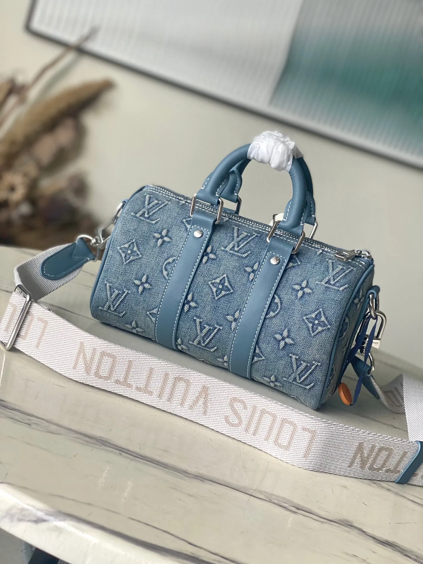 💰1060 Top-quality original M22762 denim This Keepall Bandoulière 25 handbag displays the vintage texture of Monogram Washed Demin canvas. The Monogram pattern is outlined with embossing and hand-painting techniques, as if it were a faded denim that has been baptized by time. It is paired with a retro-style nameplate and a detachable and adjustable shoulder strap. Dimensions: 25 x 15 x 11 cm