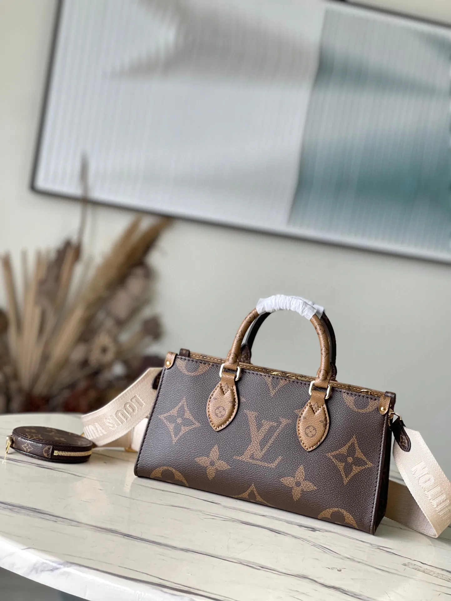 💰860 Top Original M46653 OnTheGo Tote Bag combines Giant Monogram and Monogram Reverse canvas to reinterpret the ample configuration of East West. The detachable round coin pouch is richly detailed, while the Toron top handle and detachable wide shoulder strap allow for multiple carrying options. Size: 25*13*10 cm