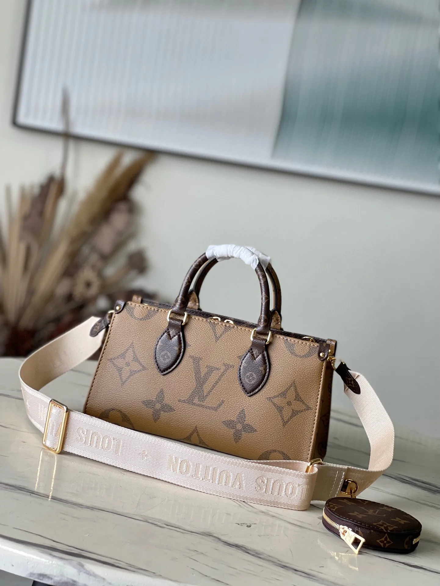 💰860 Top Original M46653 OnTheGo Tote Bag combines Giant Monogram and Monogram Reverse canvas to reinterpret the ample configuration of East West. The detachable round coin pouch is richly detailed, while the Toron top handle and detachable wide shoulder strap allow for multiple carrying options. Size: 25*13*10 cm