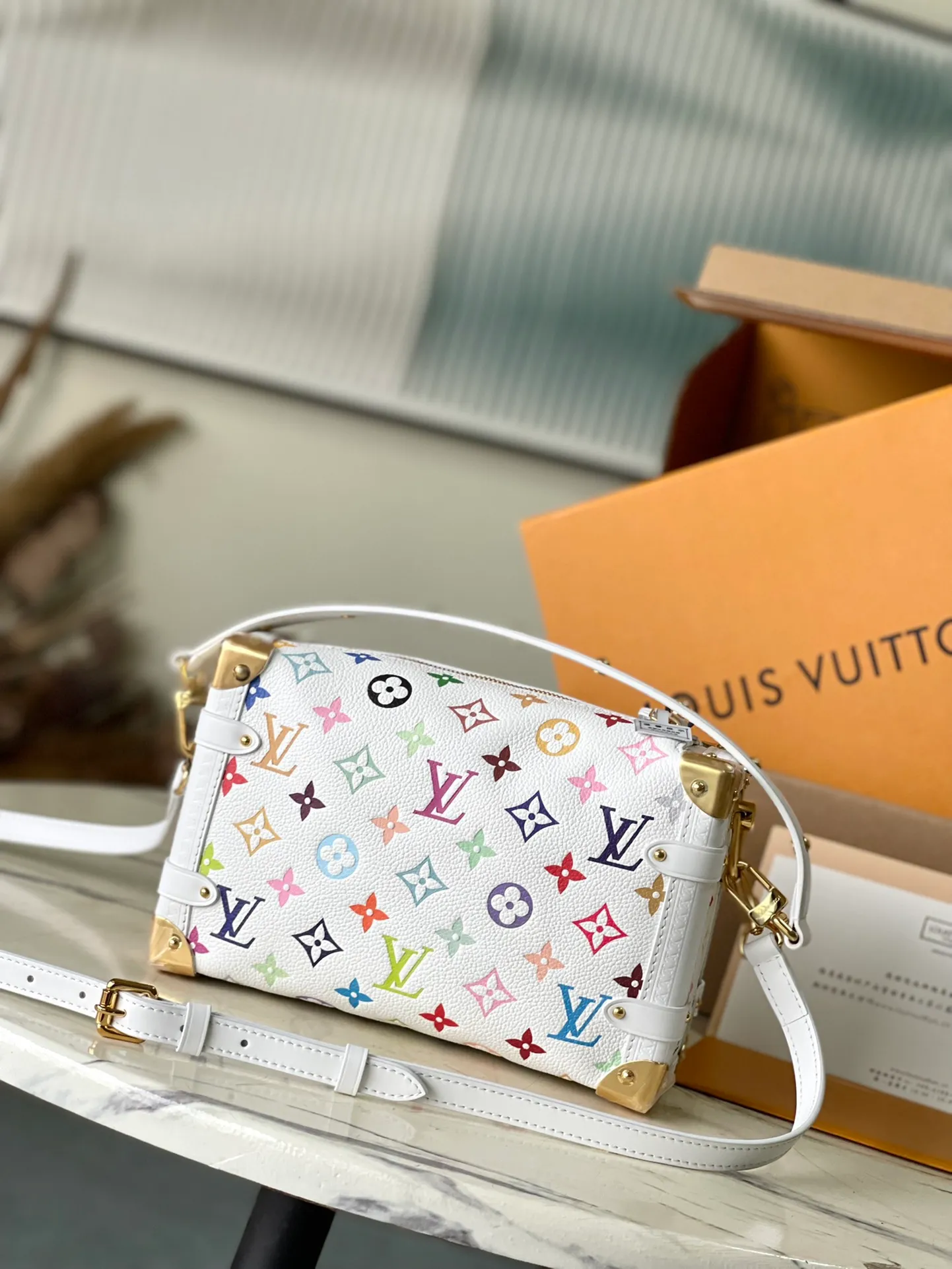 💰1220 (first-grain leather) Top-quality original item M14046 This medium-sized Side Trunk handbag uses a humorous Monogram pattern to express the smart style of the x Murakami Takashi reissue series. It is made of soft cow leather with reinforced metal corners and the iconic S-lock lock, which can easily accommodate daily needs. The square shape is a nod to the brand's classic luggage, and the removable studded handle and shoulder strap allow for flexible carrying. Dimensions: 23.5 × 16 × 8.5 cm