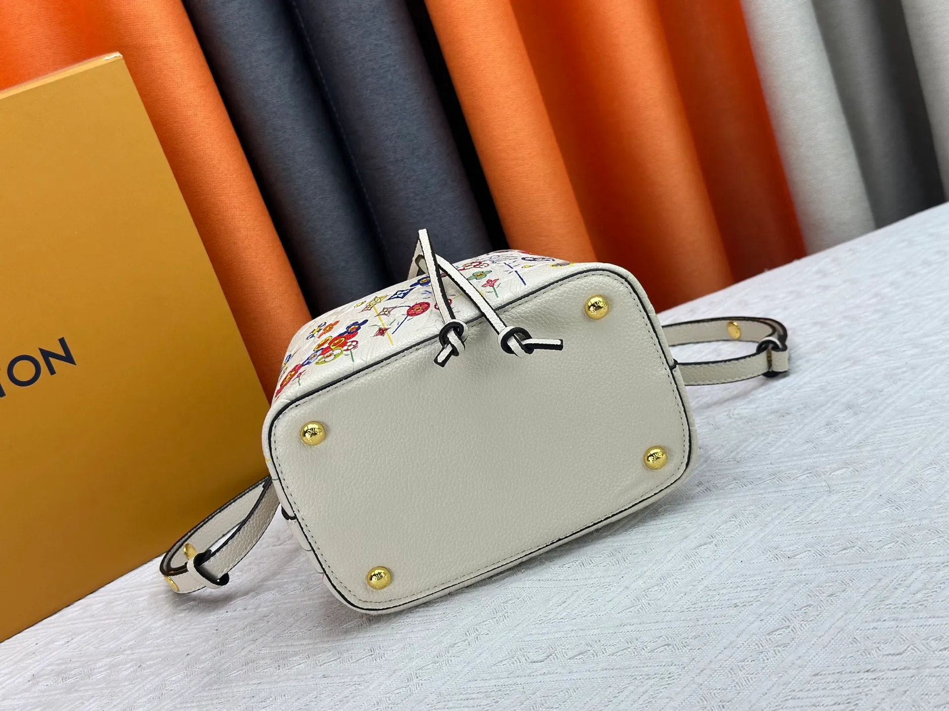P240 M13676 M44021 This NeoNoe BB bucket bag comes from the Louis Vuitton × Murakami replica series, using Monogram Empreinte leather to convey a fresh breath and smart style. Murakami's signature Cherry Blossom pattern appears on the Monogram embossed surface, and the same floral element is transformed into a slide buckle to tighten the drawstring. Size: 20x20x13cm