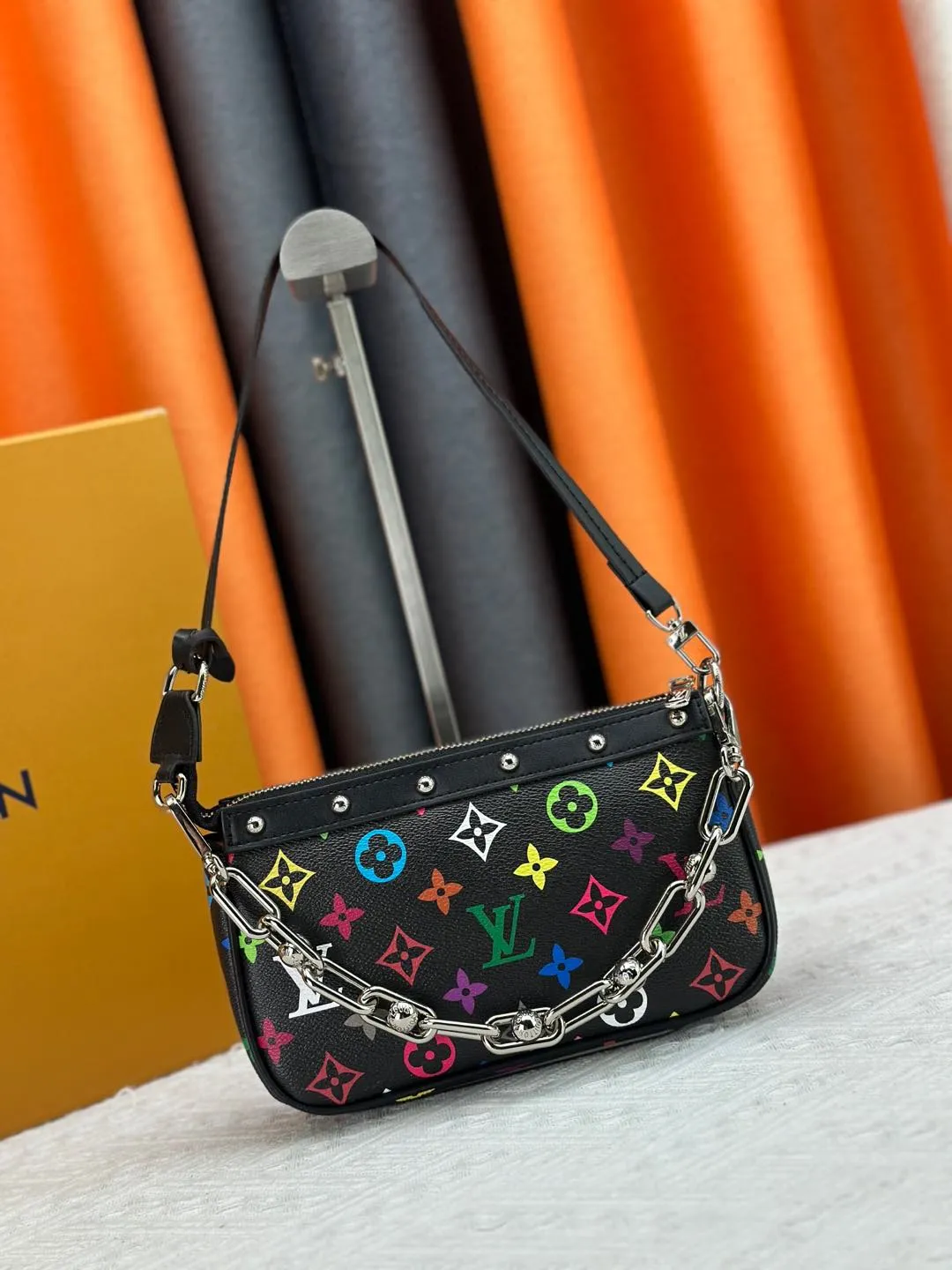 P220 M13404 M13663 Black color White color This Pochette Accessoires handbag is made of coated canvas, with colorful Monogram patterns to interpret the smart style of the Louis Vuitton × Murakami cross-border collaboration series. Calf leather trim and dazzling hardware add to the sophisticated details, while the detachable shoulder strap and chain provide flexible carry. Size: 22x13x4cm