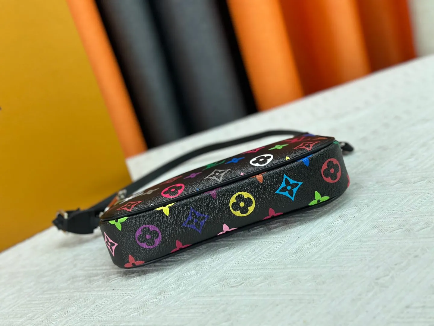P220 M13404 M13663 Black color White color This Pochette Accessoires handbag is made of coated canvas, with colorful Monogram patterns to interpret the smart style of the Louis Vuitton × Murakami cross-border collaboration series. Calf leather trim and dazzling hardware add to the sophisticated details, while the detachable shoulder strap and chain provide flexible carry. Size: 22x13x4cm