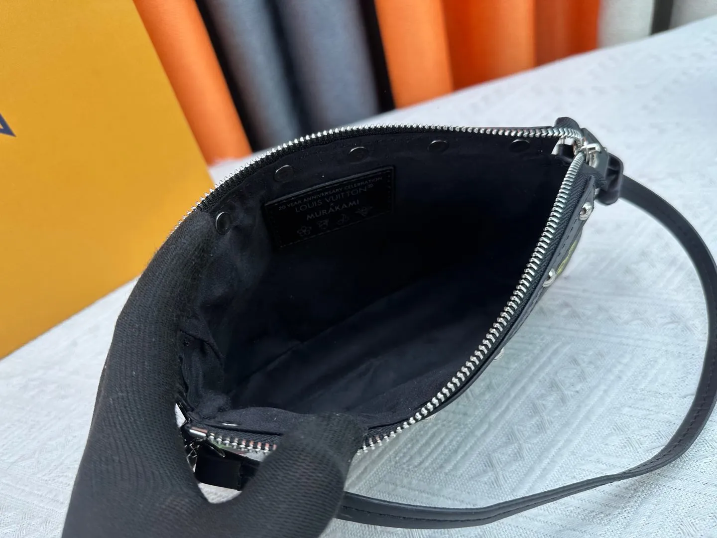 P220 M13404 M13663 Black color White color This Pochette Accessoires handbag is made of coated canvas, with colorful Monogram patterns to interpret the smart style of the Louis Vuitton × Murakami cross-border collaboration series. Calf leather trim and dazzling hardware add to the sophisticated details, while the detachable shoulder strap and chain provide flexible carry. Size: 22x13x4cm