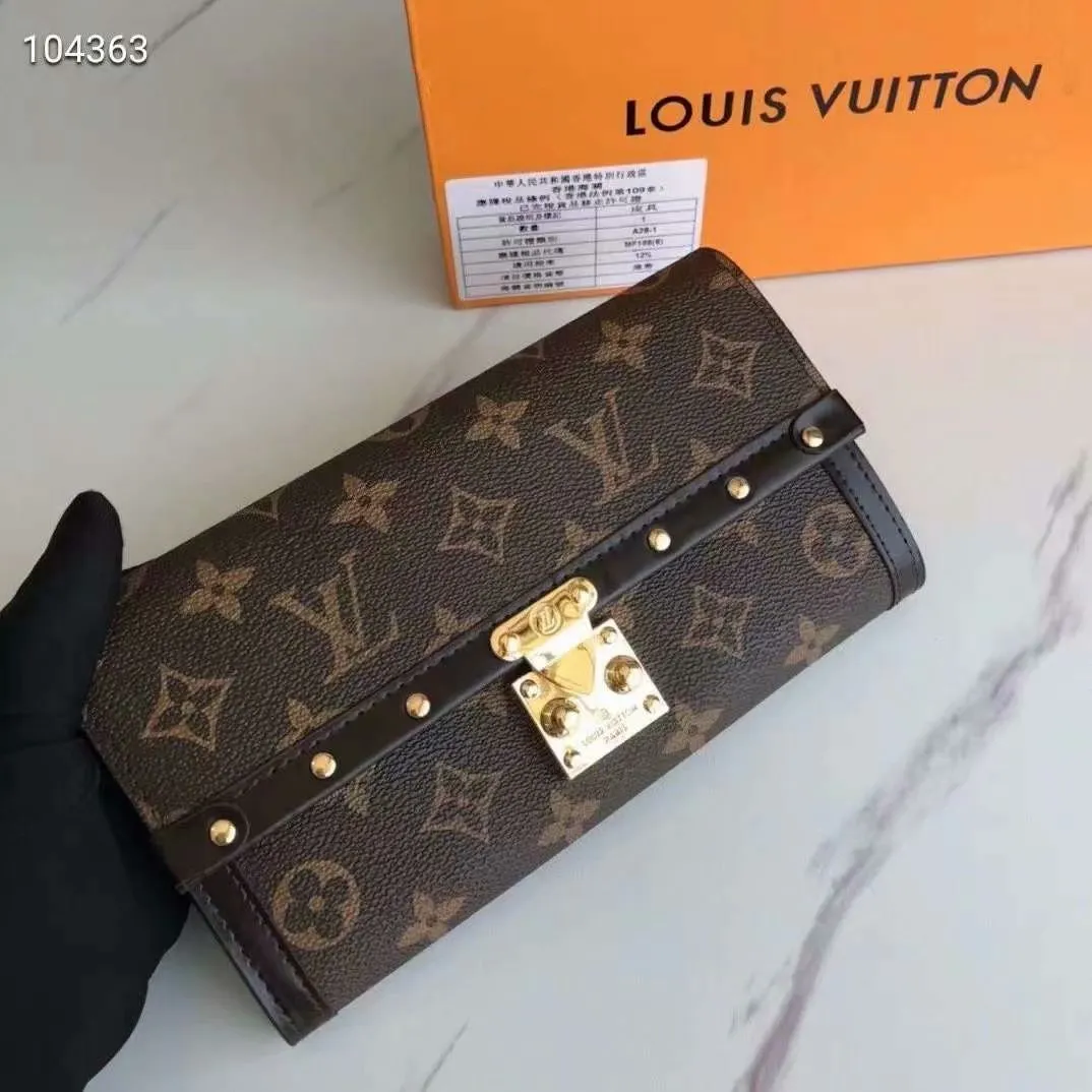 P160N60535 Material: PVC with cowhide leather Size: 21/10 Crafted from Damier Ebene canvas and decorated with the iconic S lock and rivets, this stylish Venice wallet pays homage to Louis Vuitton’s rich heritage as a luxury luggage manufacturer. Thanks to its spacious and functional interior, this model can also be used as an elegant clutch.