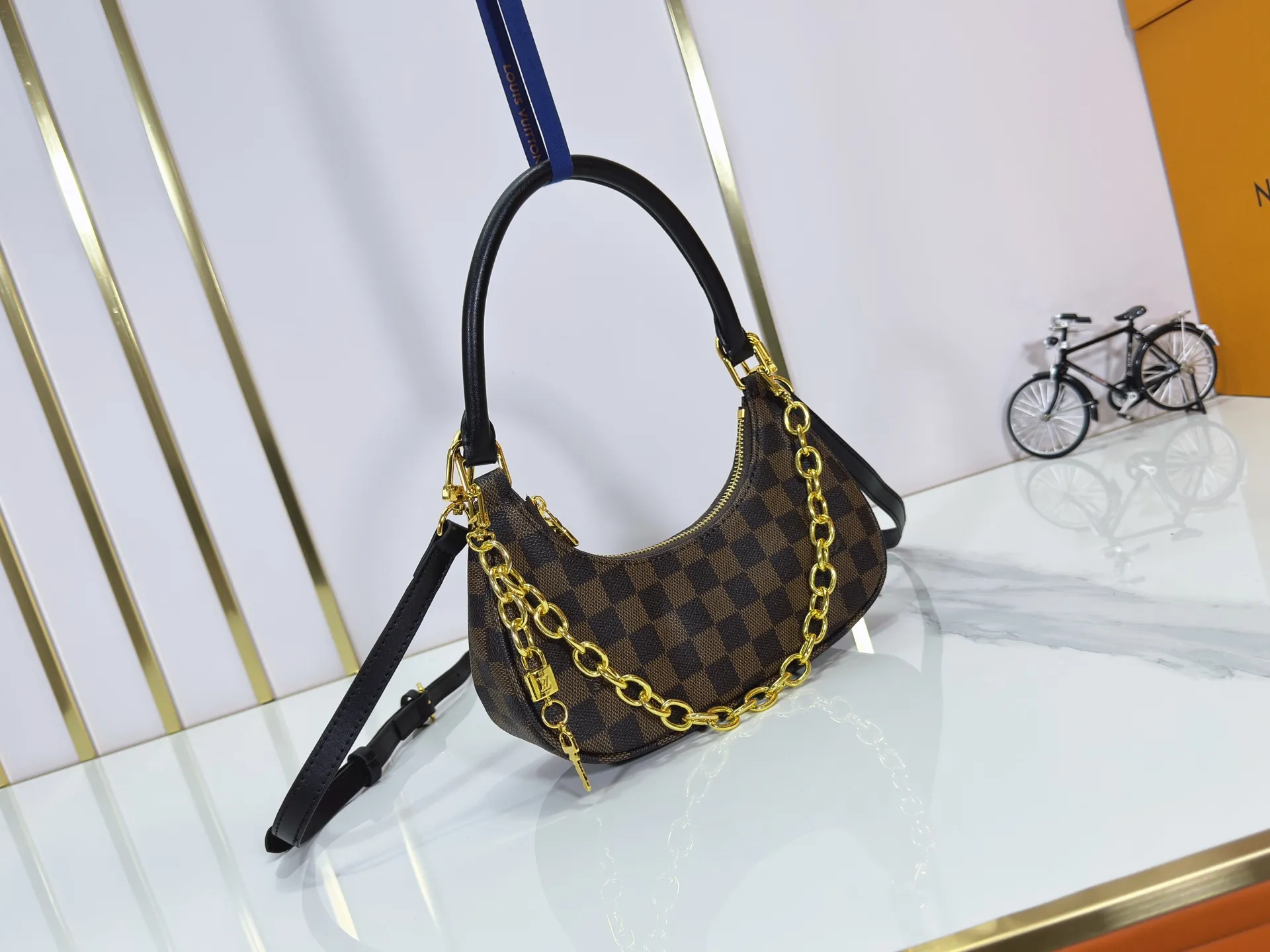 P240 Upgraded original M25223 This small Catchy handbag is made of canvas and trimmed with cow leather. It pays homage to the brand's heritage with the classic Monogram pattern, making it another smart choice. The neat structure makes it easy to carry your daily needs. The double-sided sliding straps make it easy to adjust the contours of the bag. The detachable metal chain complements the key-shaped decoration. Dimensions: 24.0 x 10.0 x 6.0 cm (length x height x width)