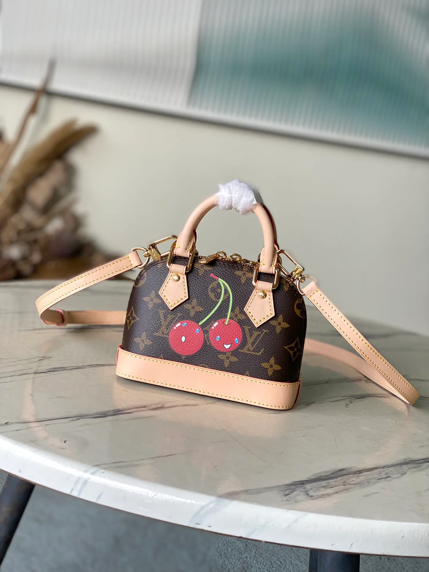💰780 Top Original Order M13416 (82717 Cherry) This compact Nano Alma is embellished with the interesting cherry pattern of the replica Louis Vuitton x Murakami series, highlighting the playful style of the handbag. The handbag is made of Monogram coated canvas and trimmed with natural cowhide leather. It also features many classic brand elements, including top handles and a detachable shoulder strap with adjustable length, allowing it to be carried in a variety of ways. The bag is suitable for storing daily essentials, including a small wallet and a large smartphone.  18 x 12 x 8 cm (length x height x width)