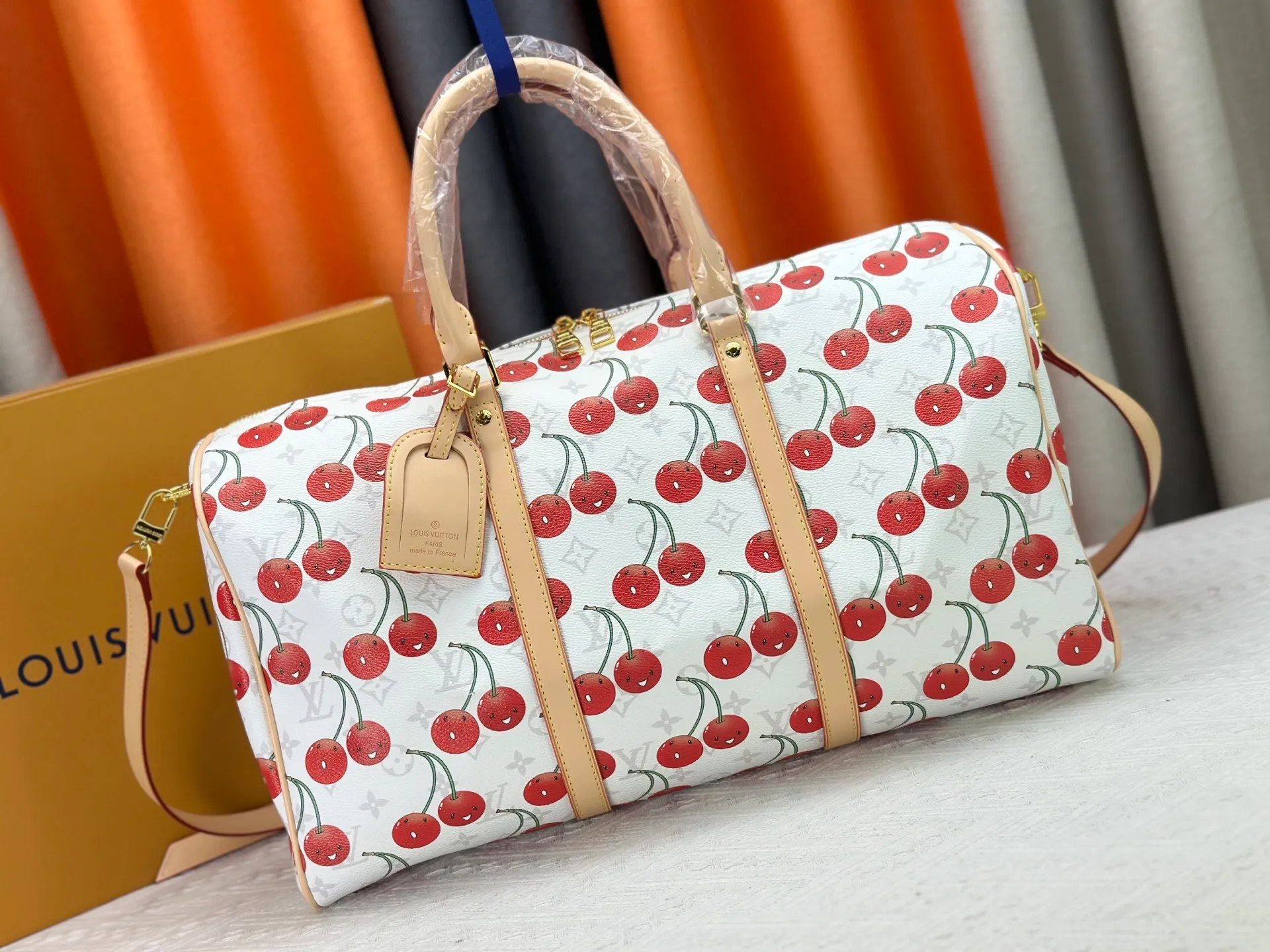 230 M13764 M41416 🍒Keepall Bandoulière 45 travel bag has a new look with the Louis Vuitton x Takashi Murakami replica series. Classic Monogram canvas features a patchwork pattern of sweet cherries and a bold lining that reflects the playful aesthetic of renowned Japanese artist Takashi Murakami. Side straps, top handles and adjustable shoulder straps reveal the natural color of the leather, while dazzling hardware completes the look.  27 x 20 x 45 cm (H x W x L) Carry-on dimensions Monogram coated canvas Cow leather trim Textile lining Metal hardware Double zipper closure Internal zip pocket Padlock Designer tag, hot stampable Shoulder strap: removable, adjustable Half-length strap: 36.0 cm Half-length strap adjustable to: 50.0 cm Handle: Double handle