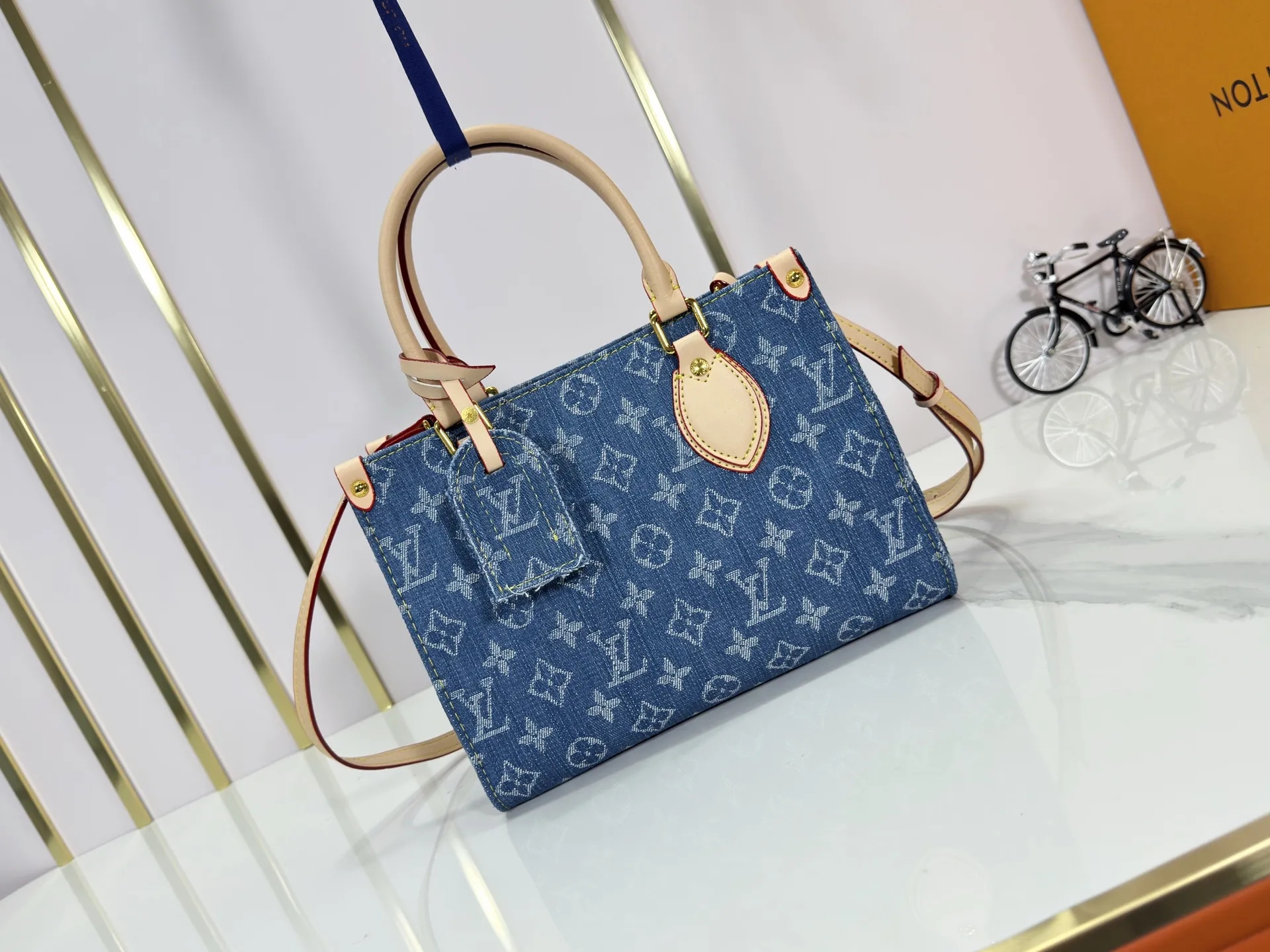 P260 Upgraded original M14633 M46373 Blue denim denim square bag This small OnTheGo handbag is made of cotton denim woven with Monogram pattern. It is bleached and sand washed to present a retro style. Detachable and Adjustable Shoulder Strap for a Subtle Fit The detachable shoulder strap makes it easy to carry small items like an iPad Mini with you. Detailed features 25x 19 x 11.5 cm.