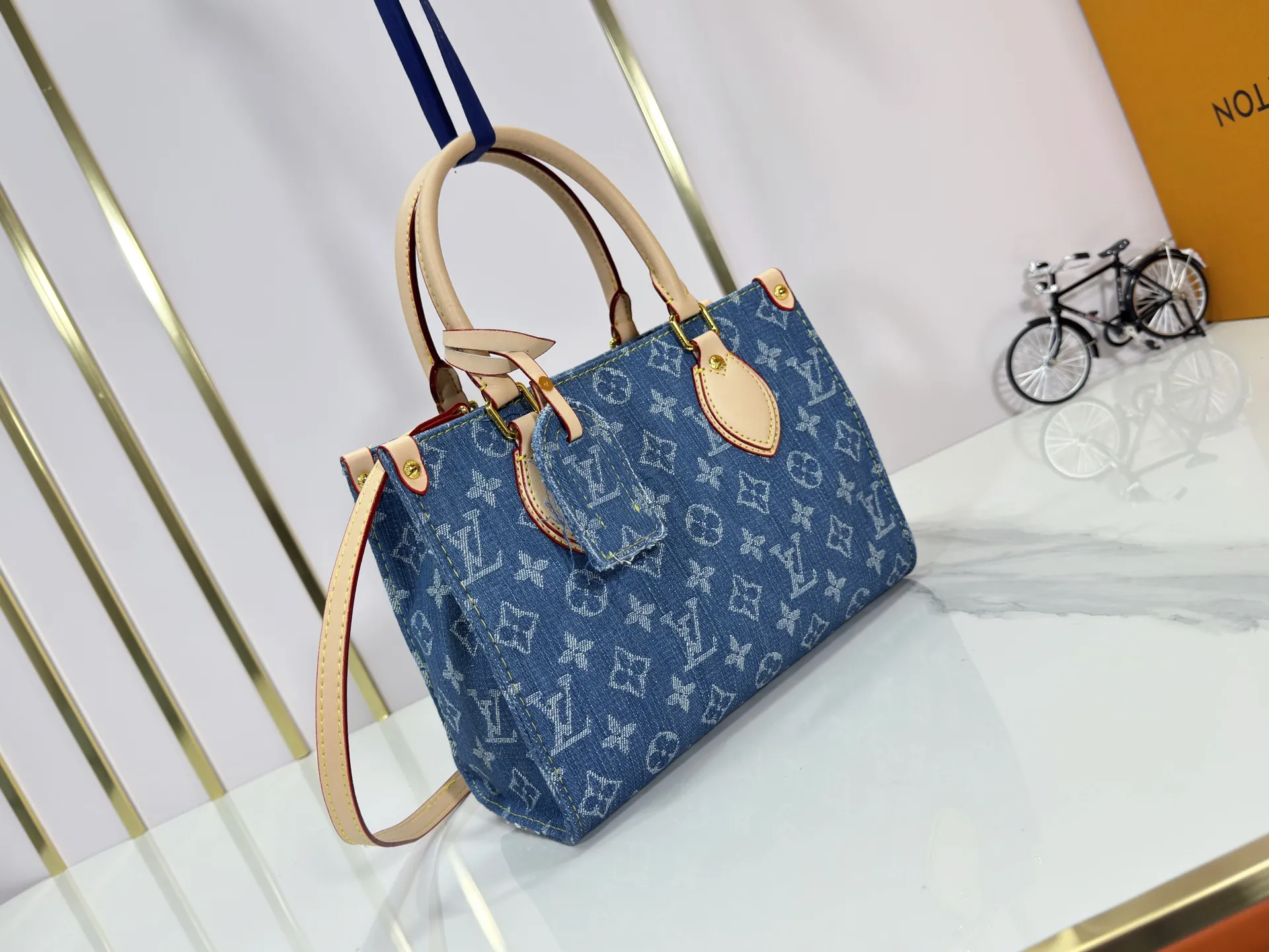 P260 Upgraded original M14633 M46373 Blue denim denim square bag This small OnTheGo handbag is made of cotton denim woven with Monogram pattern. It is bleached and sand washed to present a retro style. Detachable and Adjustable Shoulder Strap for a Subtle Fit The detachable shoulder strap makes it easy to carry small items like an iPad Mini with you. Detailed features 25x 19 x 11.5 cm.
