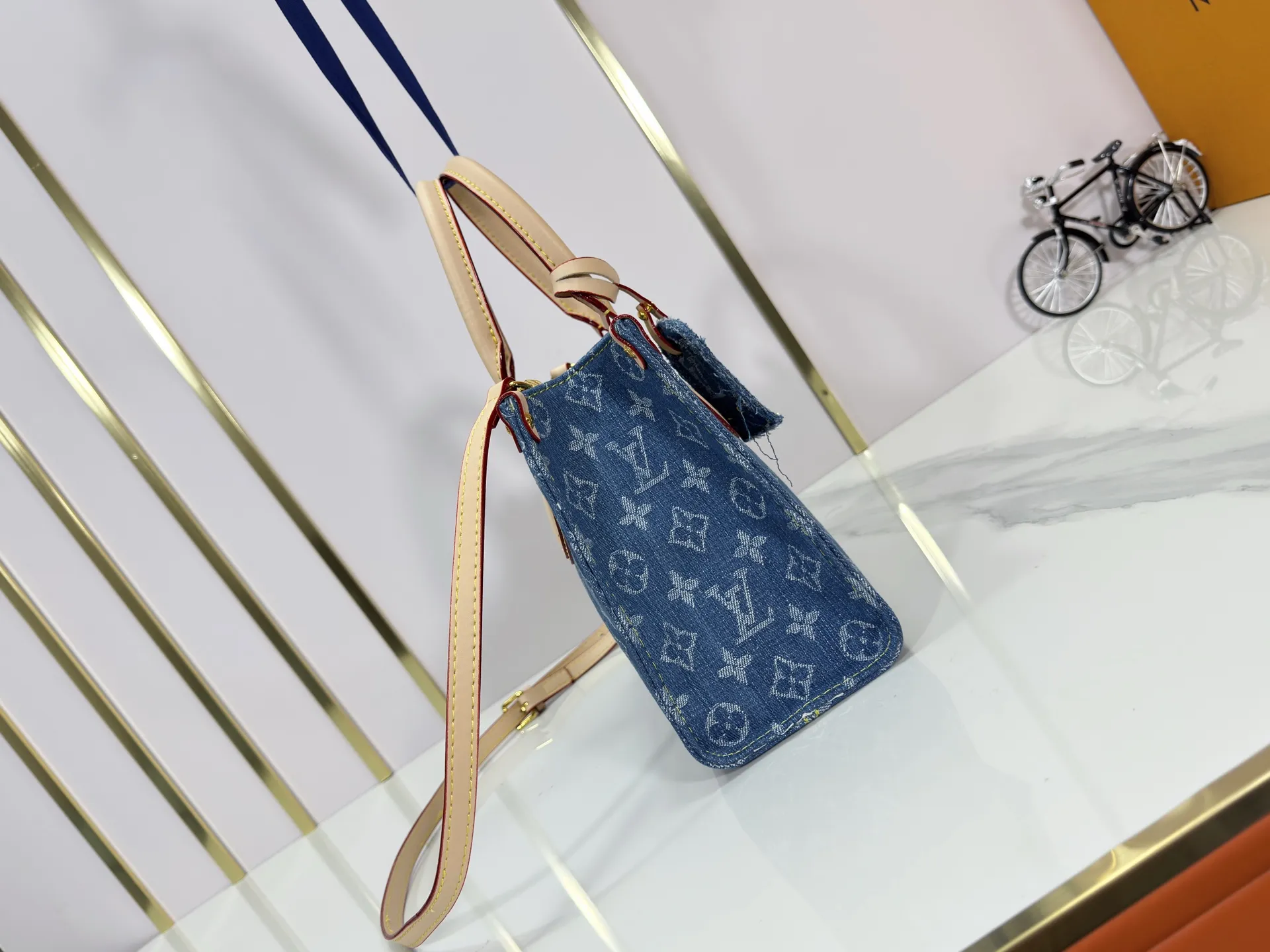 P260 Upgraded original M14633 M46373 Blue denim denim square bag This small OnTheGo handbag is made of cotton denim woven with Monogram pattern. It is bleached and sand washed to present a retro style. Detachable and Adjustable Shoulder Strap for a Subtle Fit The detachable shoulder strap makes it easy to carry small items like an iPad Mini with you. Detailed features 25x 19 x 11.5 cm.
