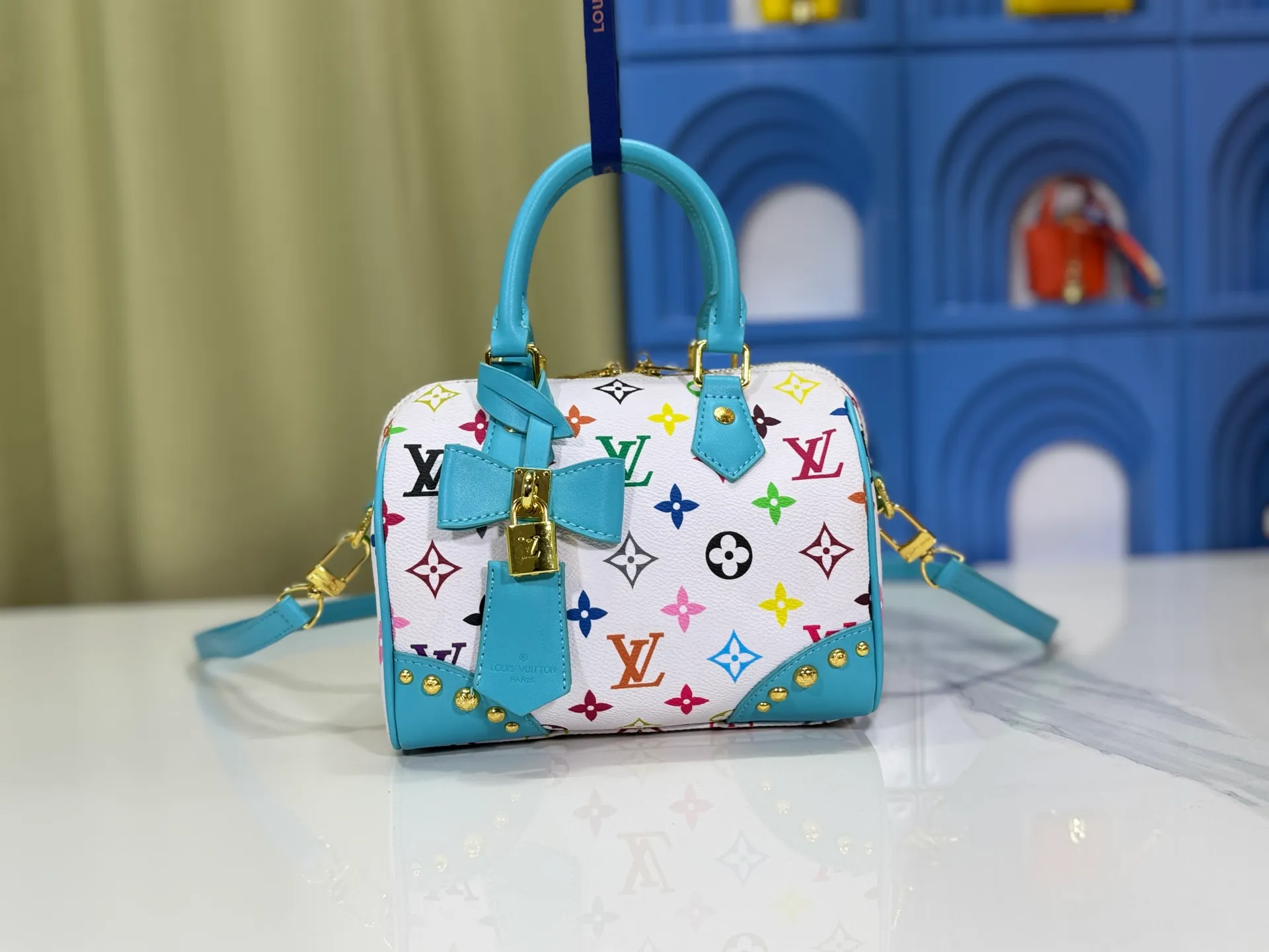 P280 upgraded original M58953 M46234 M46222 Speedy Bandoulière 20 handbag is made of soft coated canvas, and the full-length Monogram pattern is traced in colorful rainbow tones, highlighting the smart style of the Louis Vuitton x Murakami reissue series. The Toron handle and detachable shoulder strap are constructed of cow leather, the metal corners recall classic luggage elements, and the bow-shaped key bag and padlock add brand touches. Dimensions: 20.5 x 13.5 x 12.0 cm (length x height x width)