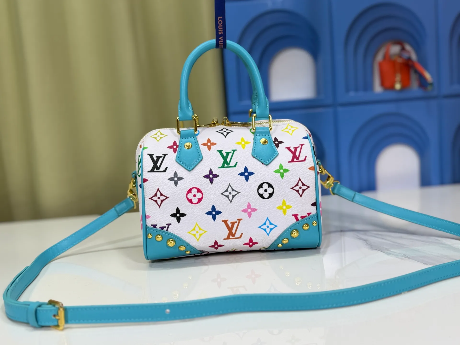 P280 upgraded original M58953 M46234 M46222 Speedy Bandoulière 20 handbag is made of soft coated canvas, and the full-length Monogram pattern is traced in colorful rainbow tones, highlighting the smart style of the Louis Vuitton x Murakami reissue series. The Toron handle and detachable shoulder strap are constructed of cow leather, the metal corners recall classic luggage elements, and the bow-shaped key bag and padlock add brand touches. Dimensions: 20.5 x 13.5 x 12.0 cm (length x height x width)