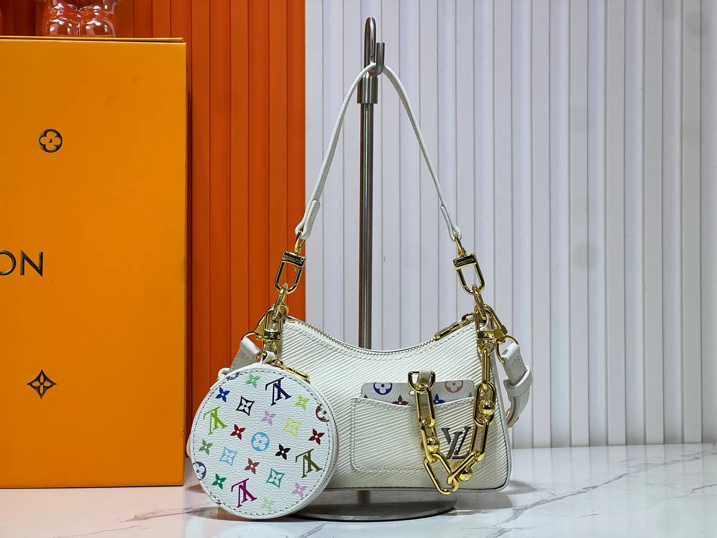 Batch 240💰M13099 This Marellini handbag is made of rich-textured Epi leather to create a delicate structure with ample space to store daily necessities such as smartphones. The round coin purse and mirror are both made of the colorful Monogram canvas from the Louis Vuitton x Takashi Murakami collaboration series, and are fixed to the bag body with a rough metal chain. Size: 19x13.5x6.5cm