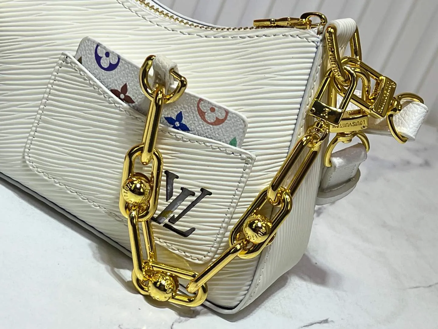 Batch 240💰M13099 This Marellini handbag is made of rich-textured Epi leather to create a delicate structure with ample space to store daily necessities such as smartphones. The round coin purse and mirror are both made of the colorful Monogram canvas from the Louis Vuitton x Takashi Murakami collaboration series, and are fixed to the bag body with a rough metal chain. Size: 19x13.5x6.5cm