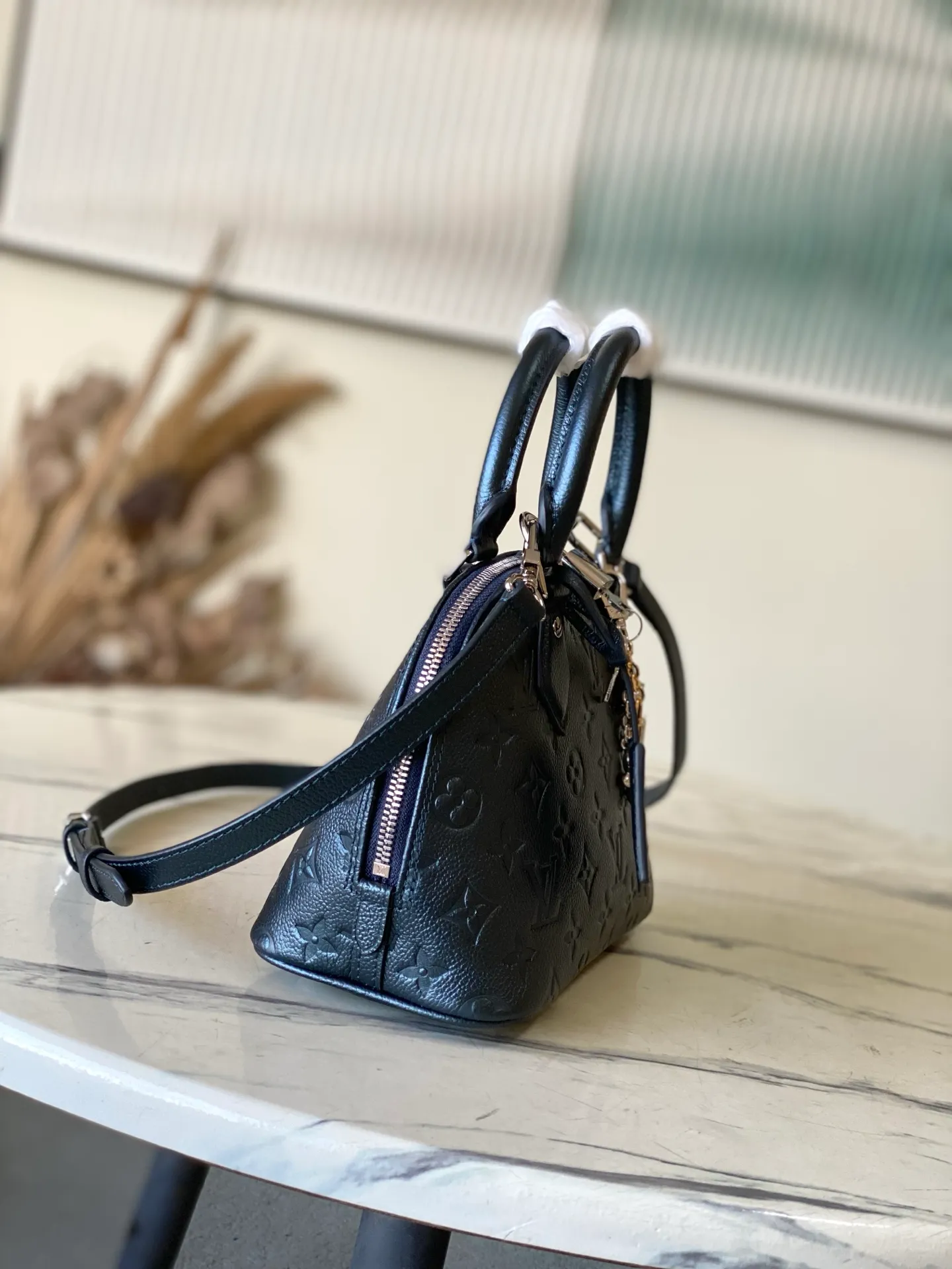 💰1140 (top layer leather) Top original order M26686 Pearlescent Blue This LV Ski version of the Alma BB bag is inspired by the magic of winter nights and decorated with this season’s exclusive sparkling hue. The model is made of Monogram Empreinte leather and features an iridescent finish and a removable tri-color metal charm that can be attached to other accessories. Among the signature details is a key bell, as well as a keyed silver padlock that pays homage to the house's suitcase heritage. Dimensions: 23.5 x 17.5 x 11.5 cm