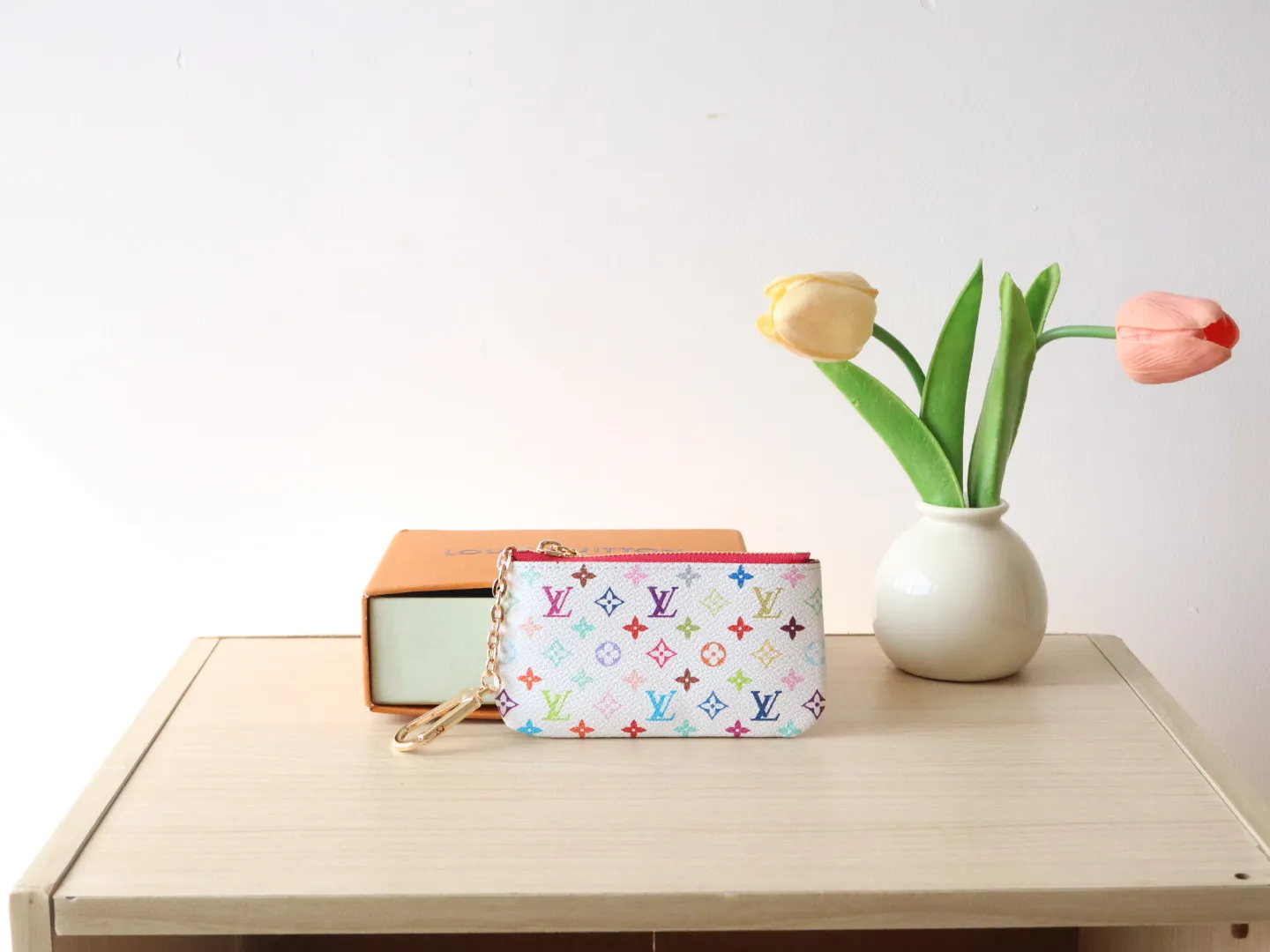 13664 Tricolor Coin Purse🌟P84 This replica Louis Vuitton x Murakami series key coin purse is colorful and made of coated canvas. The vibrant iconic Monogram pattern reinterprets the brand logo with the theme of Japanese artist Takashi Murakami in rainbow tones. The key coin purse has a silver zipper and is equipped with a chain strap and hook buckle to store keys securely. 12 x 7 x 1.5 cm (length x height x width)