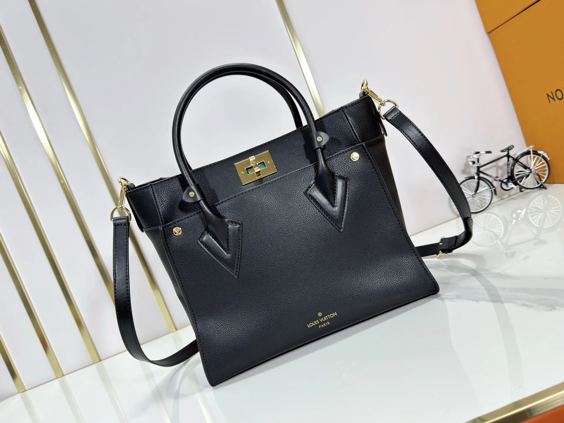 P340 upgraded original M53826 M53825 M53824 M53823On My Side handbag shows the elegant fusion of calfskin and classic Monogram canvas. Contrasting canvas shapes the large outer pocket, creating a trompe l'oeil effect as if two handbags merge into one. Plenty of space can easily accommodate office needs, and the adjustable shoulder strap allows for a cross-body style. Dimensions: 30.5 x 24.5 x 14 cm (Length x Height x Width) - Calfskin and Monogram coated canvas - Cowhide leather trim - Microfiber lining - 2 top handles for hand or elbow carry - Adjustable shoulder strap for shoulder or cross-body wear - Lock closure - 2 outer pockets with magnetic closure - Zip pocket - 1 patch pocket