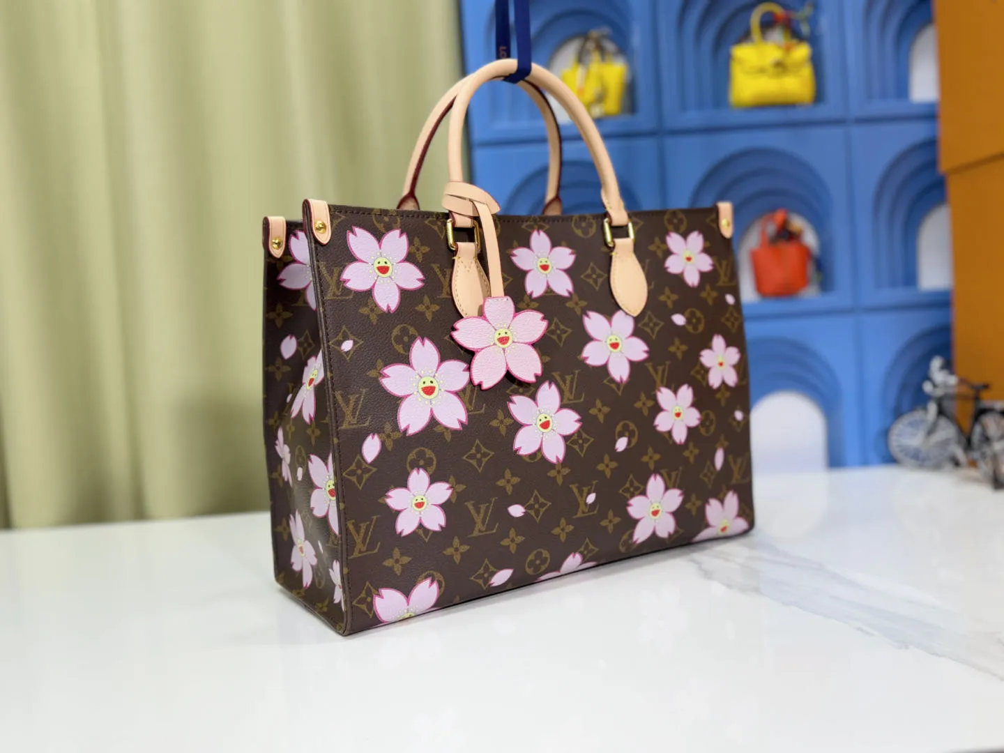 P260 M45039 M13668!🔥Lv&Takashi Murakami Sakura🌸OnTheGo new version The legendary ONTHEGO handbag: always able to meet your various needs for handbags. It has a large capacity but is not bulky. It is stiff and soft to the touch, making it suitable for home and travel. Tighten the side ties and it instantly transforms into a stylish urban handbag. Loosen the straps and it transforms into a chic and practical handbag. The slender leather handle can be carried over the shoulder or between the arms. The model shown here is made of Damier Azur canvas. Size: 35x27x14cm