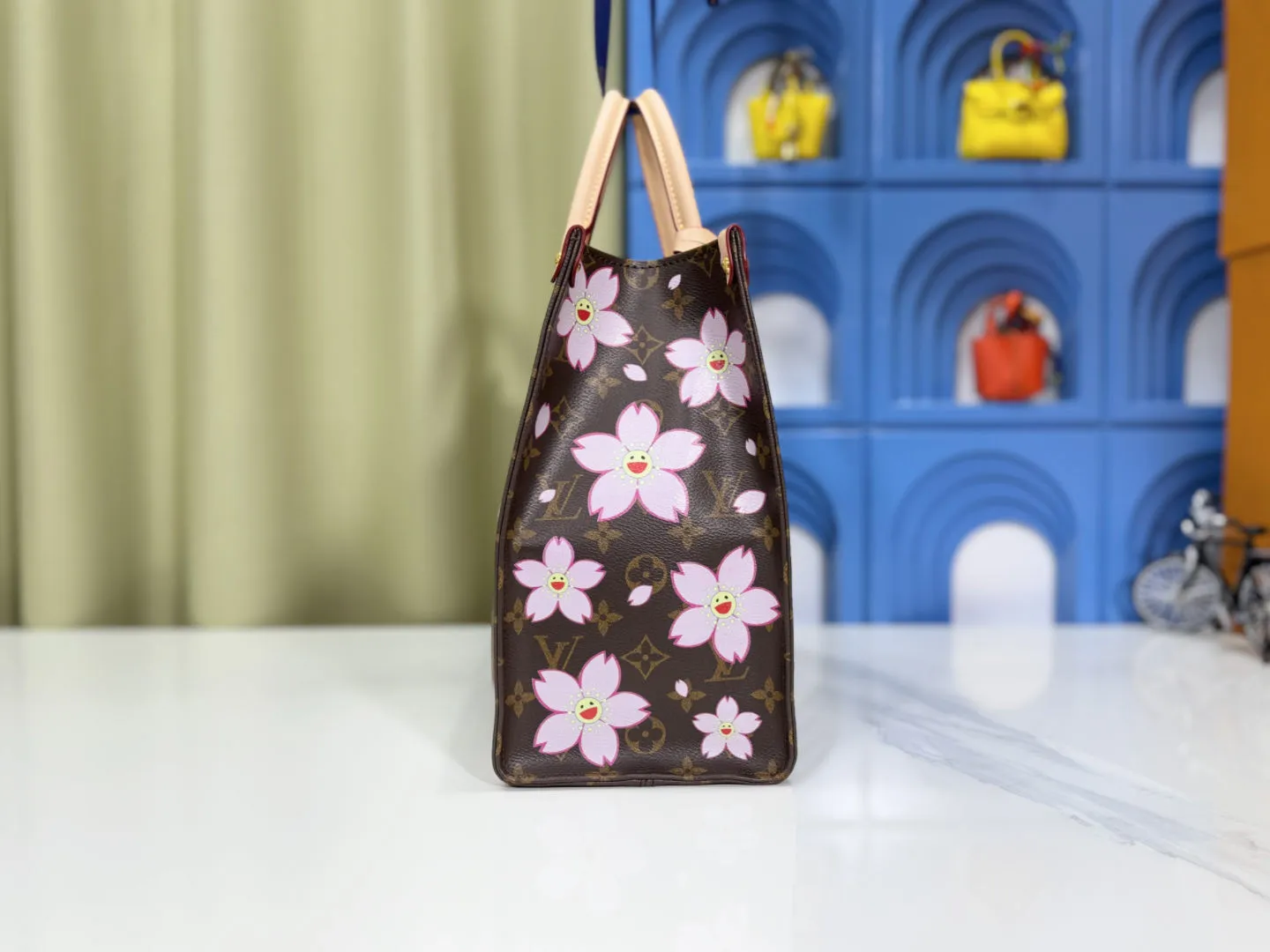 P260 M45039 M13668!🔥Lv&Takashi Murakami Sakura🌸OnTheGo new version The legendary ONTHEGO handbag: always able to meet your various needs for handbags. It has a large capacity but is not bulky. It is stiff and soft to the touch, making it suitable for home and travel. Tighten the side ties and it instantly transforms into a stylish urban handbag. Loosen the straps and it transforms into a chic and practical handbag. The slender leather handle can be carried over the shoulder or between the arms. The model shown here is made of Damier Azur canvas. Size: 35x27x14cm