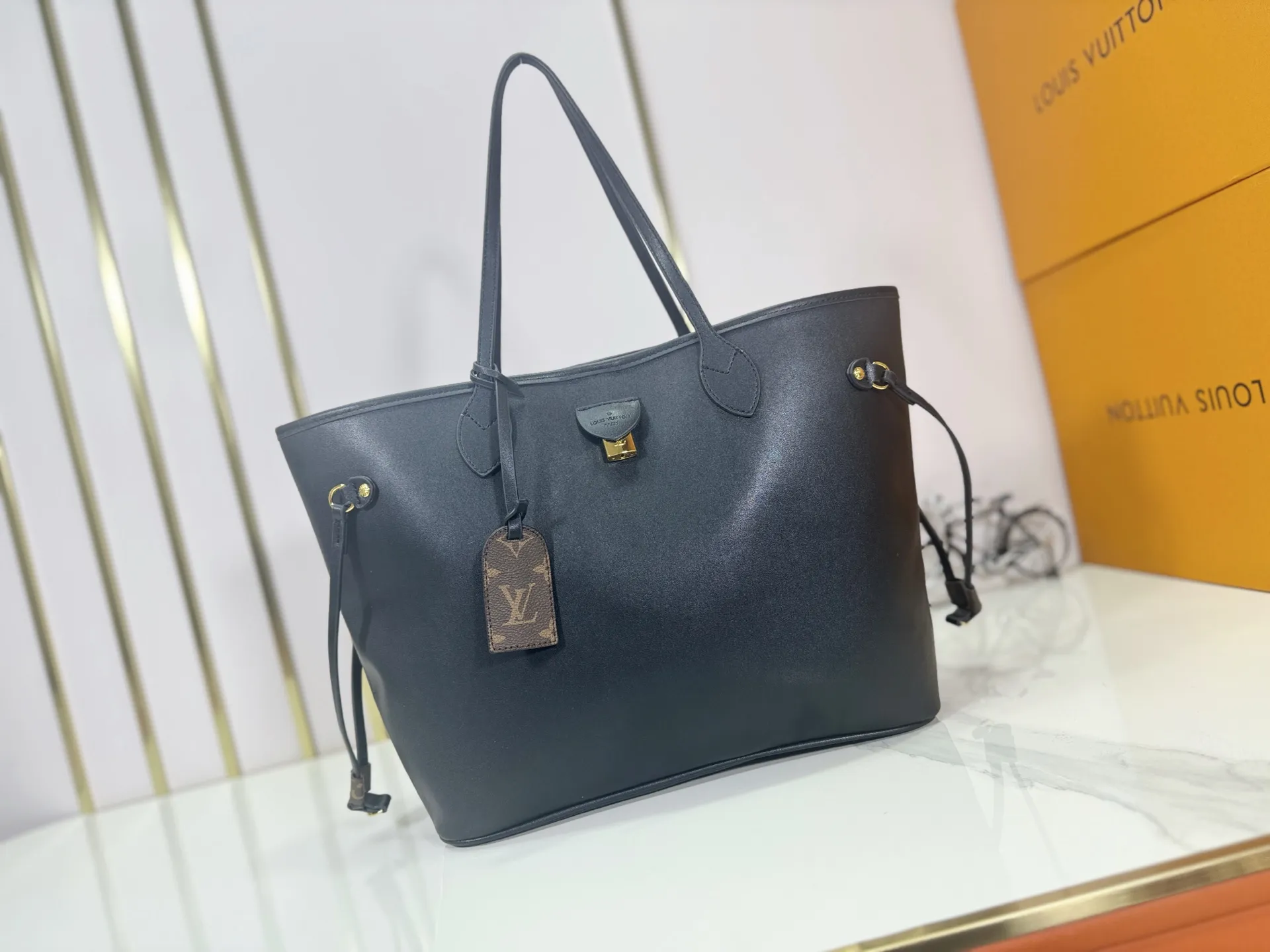 P240 Upgraded original M40995 This Neverfull MM medium handbag reinterprets the classic Monogram Empreinte leather with the same color aesthetic. The Neverfull is a roomy bag with side laces that can tighten up for a sleek allure or relax for a casual look. Inside there is a removable bag that is secured to the bag with a leather cord. Size: 32-29-17cm