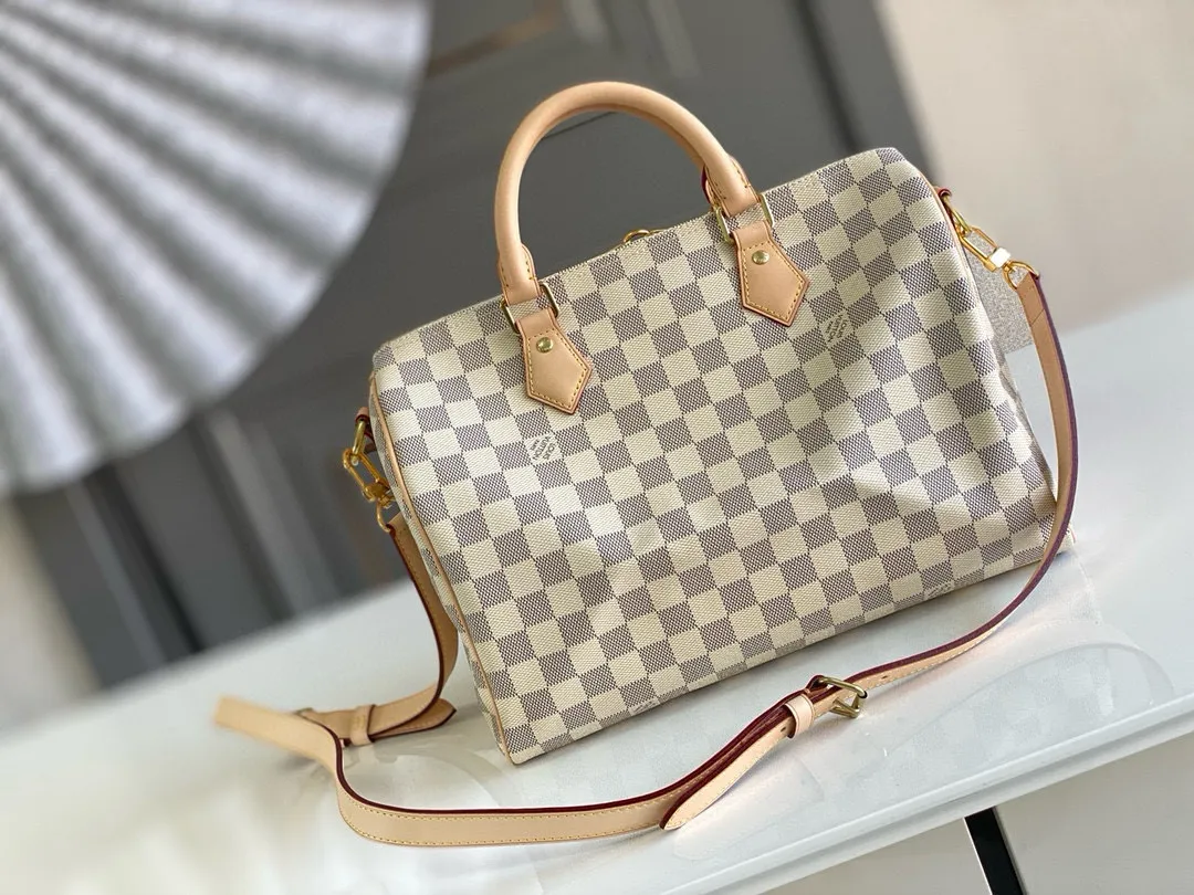 💰800 Top original N41373 SPEEDY 30 handbag (with shoulder strap) Every feature of this Speedy handbag is classic: leather handle, Damier Azur canvas. No wonder it has become a particularly popular bag in the world. Originally designed for travelers in 1930 (its name pays homage to the high-speed traffic of the time), the Speedy 30, with its cross-body strap, has become the ideal urban bag - soft, lightweight and classic. Detailed Features 30 x 21 x 17 cm (Length x Height x Width) Shiny gold-tone brass hardware and padlock Lockable double zipper closure Internal pocket D-ring for keys and accessories Soft fabric lining Shoulder strap: removable, adjustable Strap half-length: 48.0 cm Strap half-length adjustable to: 55.0 cm Handle: Double handle