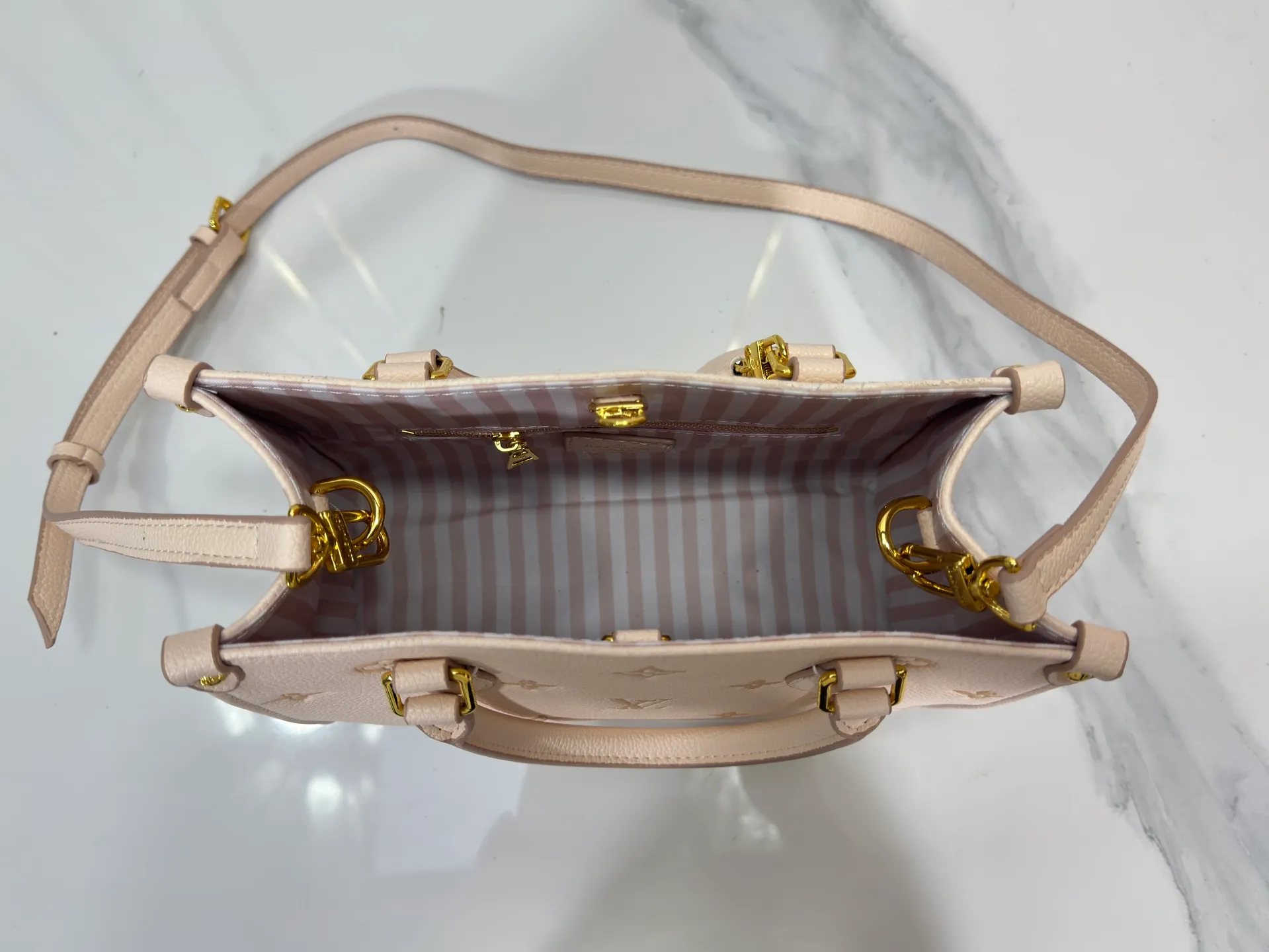 P240 upgrades the original M14403. This OnTheGo small handbag renews the brand's classic Monogram Empreinte leather, using the same tone to outline the pattern. The detachable metal chain accentuates the details, the striped fabric lining adds an elegant touch, and the detachable shoulder strap allows for shoulder or cross-body wear. 25.0 x 19.0 x 11.5 cm (length x height x width)