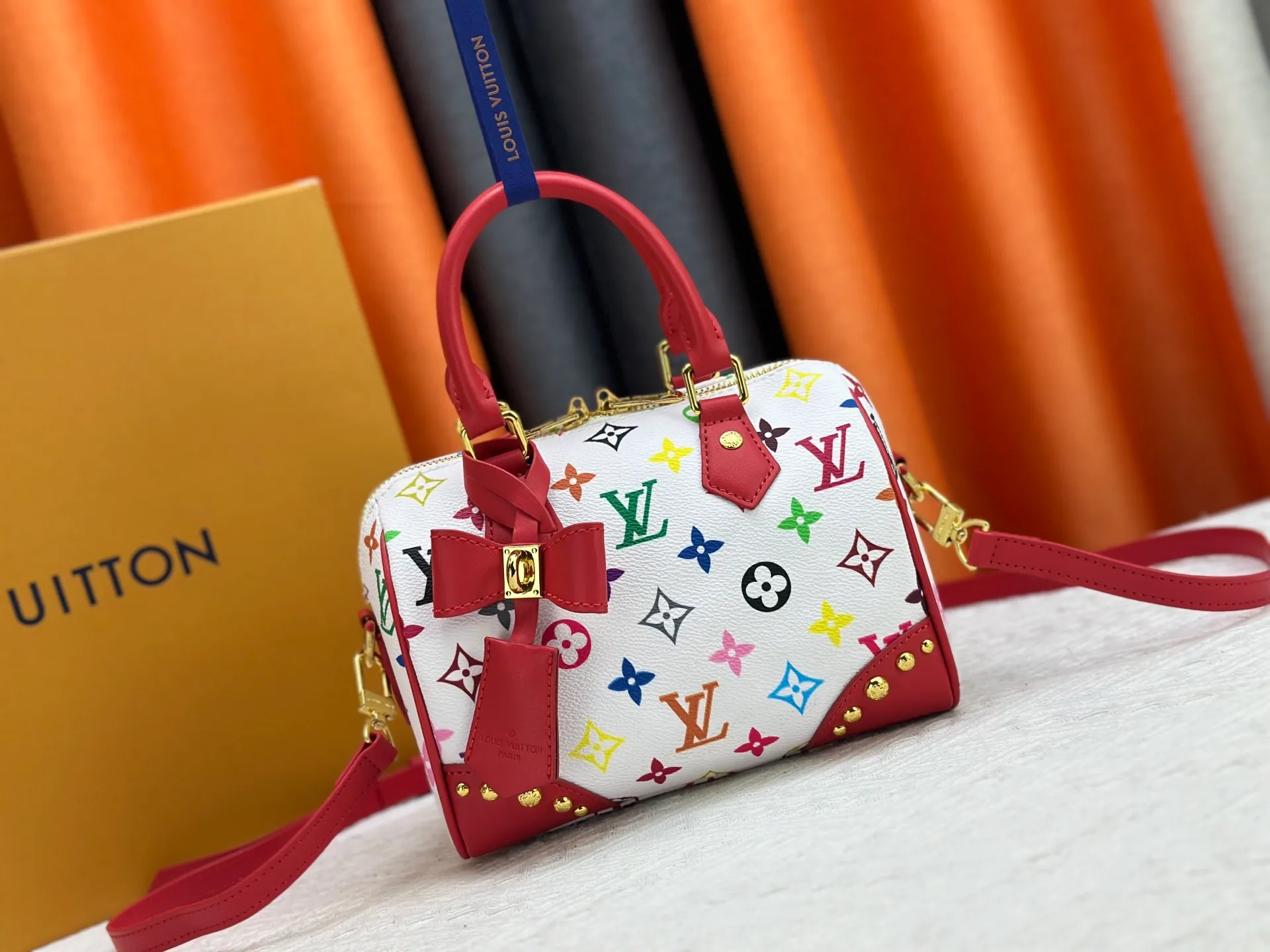 P260 upgraded original M58953 M46234 M46222 Speedy Bandoulière 20 handbag is made of soft coated canvas, and the full-length Monogram pattern is traced in colorful rainbow tones, highlighting the smart style of the Louis Vuitton x Murakami reissue series. The Toron handle and detachable shoulder strap are constructed of cow leather, the metal corners recall classic luggage elements, and the bow-shaped key bag and padlock add brand touches. Dimensions: 20.5 x 13.5 x 12.0 cm (length x height x width)