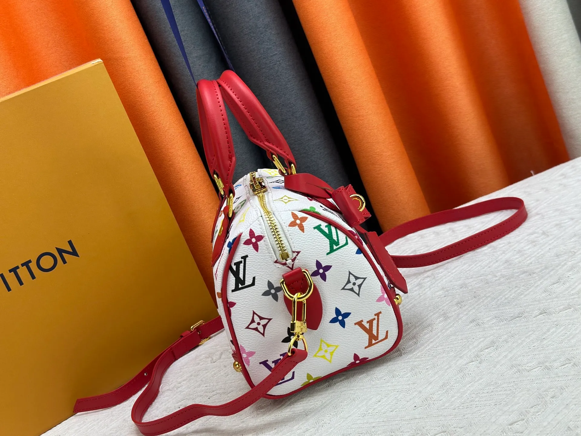 P260 upgraded original M58953 M46234 M46222 Speedy Bandoulière 20 handbag is made of soft coated canvas, and the full-length Monogram pattern is traced in colorful rainbow tones, highlighting the smart style of the Louis Vuitton x Murakami reissue series. The Toron handle and detachable shoulder strap are constructed of cow leather, the metal corners recall classic luggage elements, and the bow-shaped key bag and padlock add brand touches. Dimensions: 20.5 x 13.5 x 12.0 cm (length x height x width)