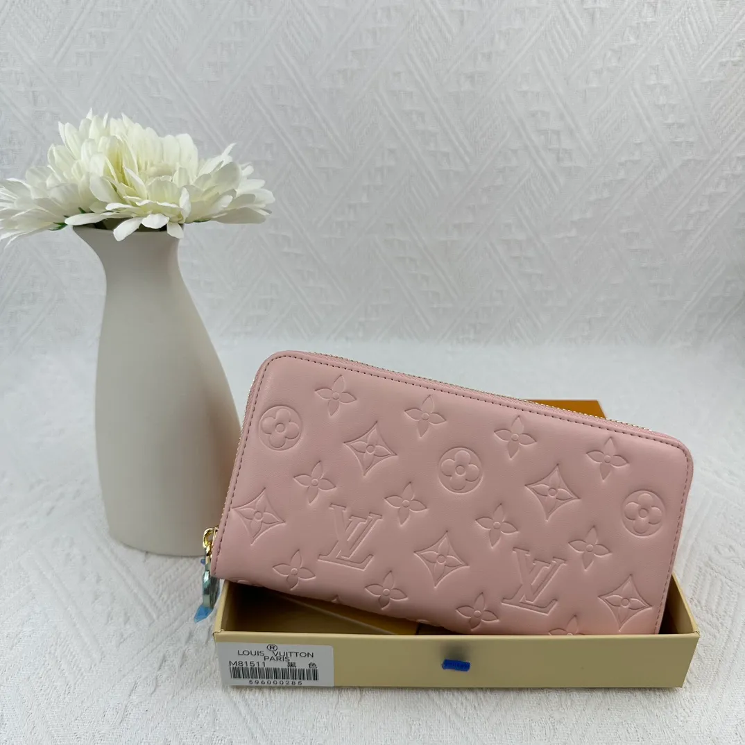 P130 M81511 Pink Stitched with padded Monogram embossed lambskin, it complements the Coussin leather boutique collection. Beautifully designed with a gold-tone zipper embossed with the LV Circle signature pull, the interior of the all-in-one wallet is packed with practical features, including three large compartments, a coin compartment and 12 business card slots. Dimensions: 19.5 x 10.5 x 2.5 cm