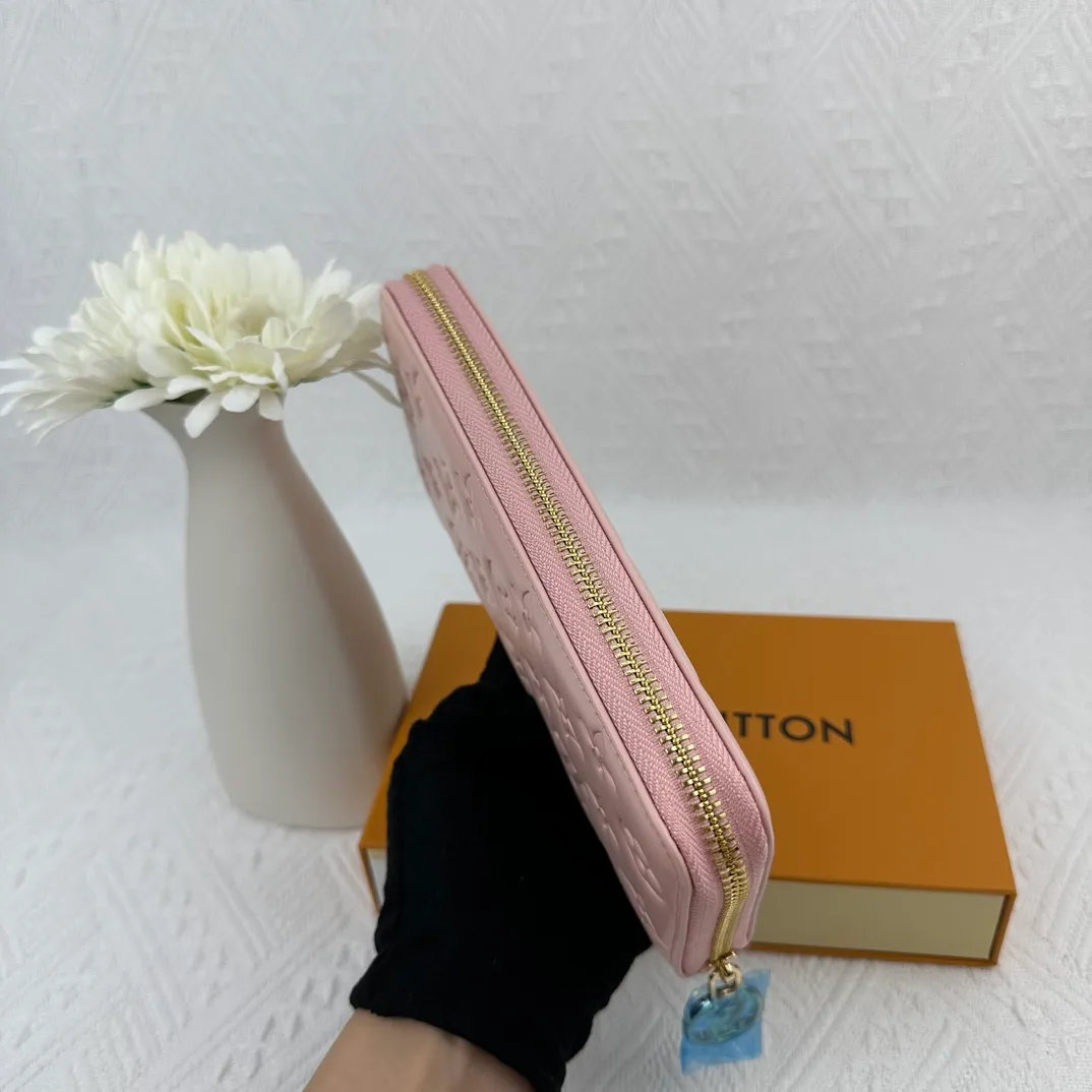 P130 M81511 Pink Stitched with padded Monogram embossed lambskin, it complements the Coussin leather boutique collection. Beautifully designed with a gold-tone zipper embossed with the LV Circle signature pull, the interior of the all-in-one wallet is packed with practical features, including three large compartments, a coin compartment and 12 business card slots. Dimensions: 19.5 x 10.5 x 2.5 cm