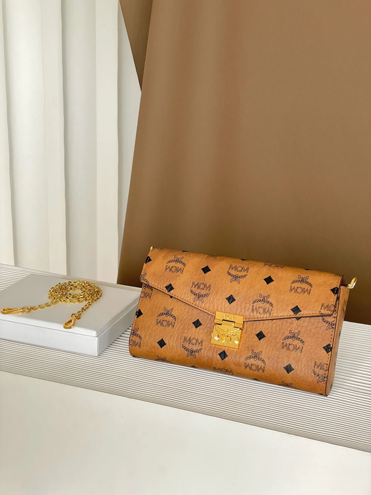 Upgraded version 💰460 with airplane case 𝐌𝐂𝐌 𝐓𝐫𝐚𝐜𝐲 𝐕𝐢𝐬𝐞𝐭𝐨𝐬 Medium pure chain envelope bag✉️ Exclusive®️Presbyopia printed all over This otherworldly Tracy crossbody bag is crafted from Italian Visetos and Nappa leather. This classic carry-on bag is accented with the signature bay leaf lock and features a lightweight, full-chain shoulder strap for effortless elegance.  Size: 23.5*5*13.5cm Shoulder strap: drop length 60cm/removable Closure: bay leaf lock Color: cognac/brown🏾