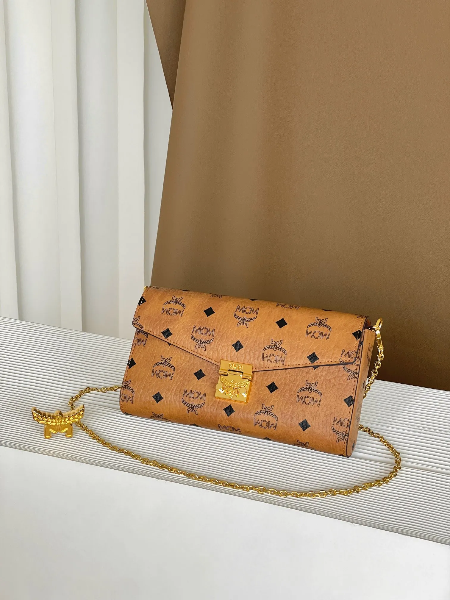Upgraded version 💰460 with airplane case 𝐌𝐂𝐌 𝐓𝐫𝐚𝐜𝐲 𝐕𝐢𝐬𝐞𝐭𝐨𝐬 Medium pure chain envelope bag✉️ Exclusive®️Presbyopia printed all over This otherworldly Tracy crossbody bag is crafted from Italian Visetos and Nappa leather. This classic carry-on bag is accented with the signature bay leaf lock and features a lightweight, full-chain shoulder strap for effortless elegance.  Size: 23.5*5*13.5cm Shoulder strap: drop length 60cm/removable Closure: bay leaf lock Color: cognac/brown🏾