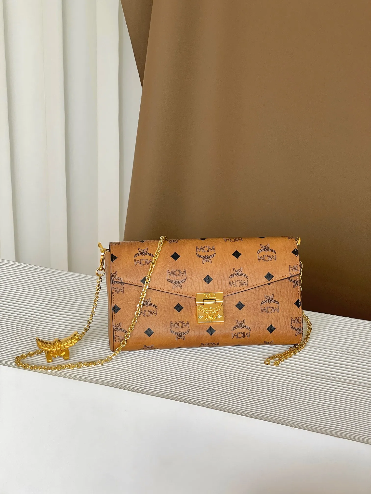 Upgraded version 💰460 with airplane case 𝐌𝐂𝐌 𝐓𝐫𝐚𝐜𝐲 𝐕𝐢𝐬𝐞𝐭𝐨𝐬 Medium pure chain envelope bag✉️ Exclusive®️Presbyopia printed all over This otherworldly Tracy crossbody bag is crafted from Italian Visetos and Nappa leather. This classic carry-on bag is accented with the signature bay leaf lock and features a lightweight, full-chain shoulder strap for effortless elegance.  Size: 23.5*5*13.5cm Shoulder strap: drop length 60cm/removable Closure: bay leaf lock Color: cognac/brown🏾