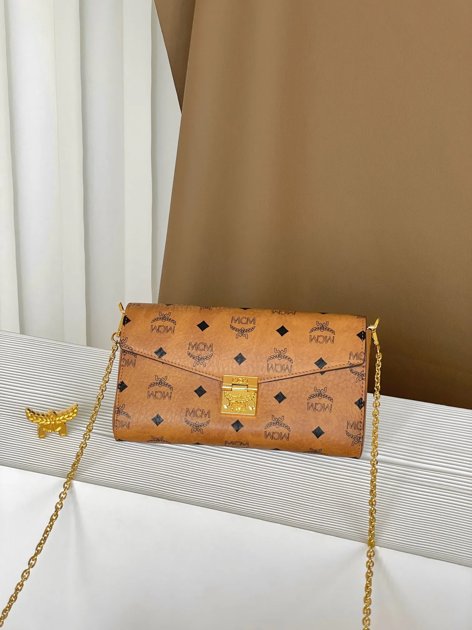 Upgraded version 💰460 with airplane case 𝐌𝐂𝐌 𝐓𝐫𝐚𝐜𝐲 𝐕𝐢𝐬𝐞𝐭𝐨𝐬 Medium pure chain envelope bag✉️ Exclusive®️Presbyopia printed all over This otherworldly Tracy crossbody bag is crafted from Italian Visetos and Nappa leather. This classic carry-on bag is accented with the signature bay leaf lock and features a lightweight, full-chain shoulder strap for effortless elegance.  Size: 23.5*5*13.5cm Shoulder strap: drop length 60cm/removable Closure: bay leaf lock Color: cognac/brown🏾