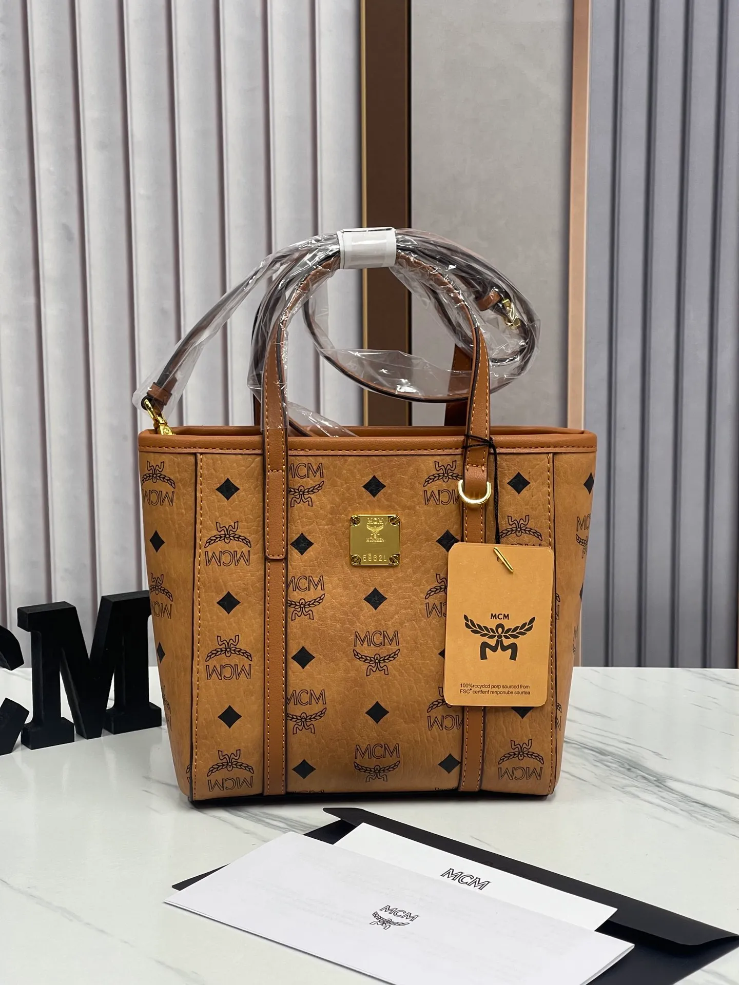 Batch 360💰🎋MCM new upgraded version·High quality✈️ Comes with environmentally friendly gift box♻️🎁Packaging model: 190820 Toni Visetos shopping bag has a new look, super beautiful👗 This compact shopping bag is multi-functional and will last forever. Don't let the size of this mini tote fool you, it's designed with spacious interior and exterior compartments to store all your small essentials. The cotton canvas lining features a print inspired by street fashion, subtly retaining MCM's adventurous aesthetic. Pair it with the included cross-body strap for hands-free functionality and greater portability. 18.5x19x9.5cm🌸