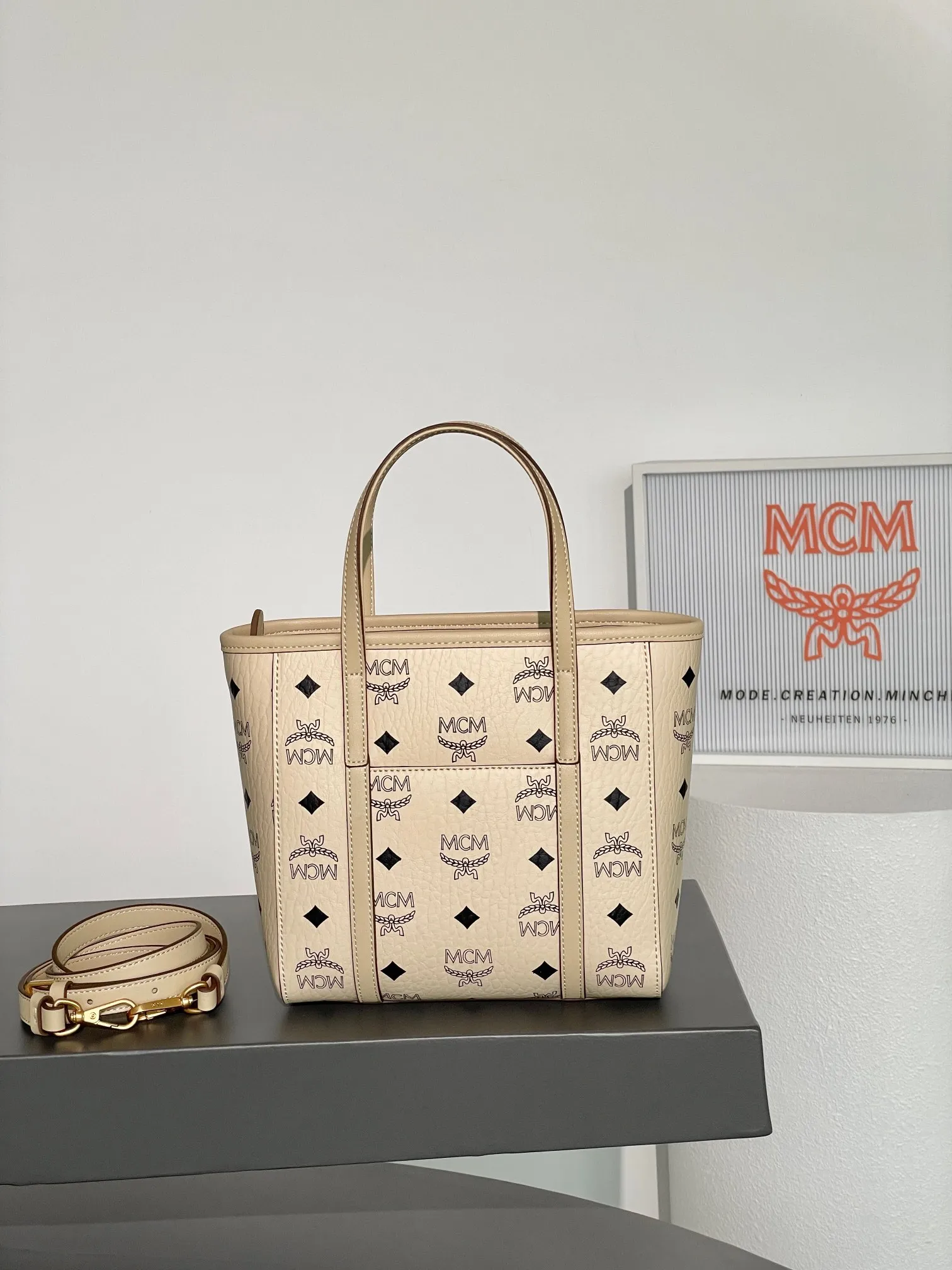 𝗠𝗖𝗠 𝗔𝗿𝗲𝗻 𝗩𝗶𝘀𝗲𝘁𝗼𝘀 𝗠𝗶𝗻𝗶 🆕New rice and cabbage basket 💰520 👏New colors, exclusive®️old flower all over print Mini Aren shopper bag in signature Visetos and trimmed in Nappa leather. The bag features a geometric design that is both unique and practical. The bag is lined in luxurious cotton canvas and features a geometric print inspired by the brand's urban spirit. The top zipper closure ensures the safety of the belongings inside. Paired with a shoulder strap, it can be carried hands-free and has unparalleled versatility. Size: 19*9.5*18.5cm Shoulder strap: 98-114cm/removable Handle: drop length 10cm Opening and closing: zipper opening Color: off-white/Beige▫️ 💰520 comes with gift box