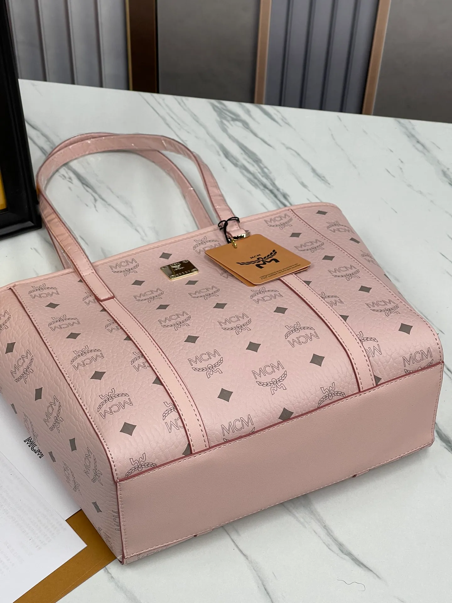 Batch 420💐MCM counter new vegetable basket·Small size [counter synchronization] with gift box🎁Packaging Model 0999 🦁️Toni shopping bag is made of classic Visetos material and decorated with soft Nappa leather trim. The trapezoidal shape combines aesthetic features with strong practicality. Inside, the luxurious cotton canvas compartment is printed with a chain-link pattern inspired by traditional street fashion, and a top zip closure keeps belongings safe. Size: 26*25 cm,