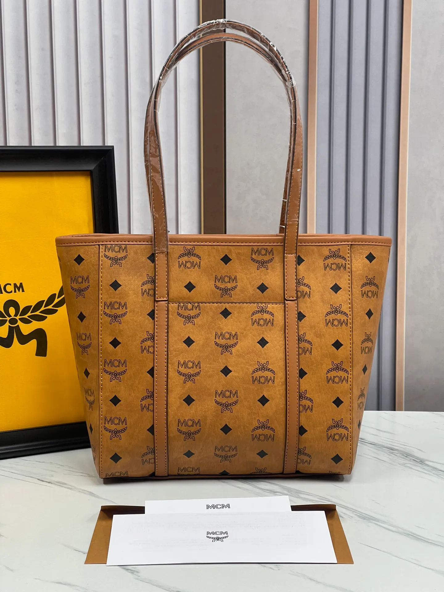 Batch 420💐MCM counter new vegetable basket·Small size [counter synchronization] with gift box🎁Packaging Model 0999 🦁️Toni shopping bag is made of classic Visetos material and decorated with soft Nappa leather trim. The trapezoidal shape combines aesthetic features with strong practicality. Inside, the luxurious cotton canvas compartment is printed with a chain-link pattern inspired by traditional street fashion, and a top zip closure keeps belongings safe. Size: 26*25 cm,