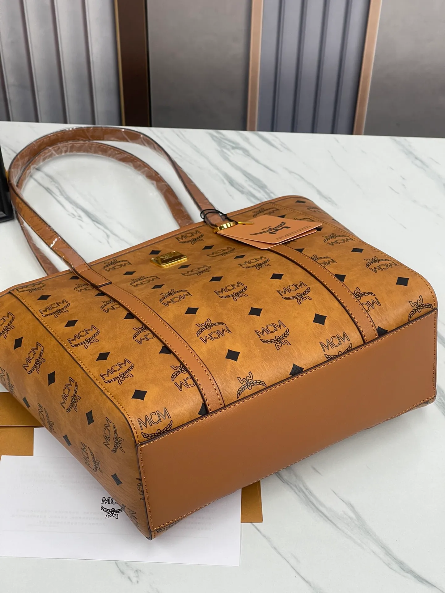 Batch 420💐MCM counter new vegetable basket·Small size [counter synchronization] with gift box🎁Packaging Model 0999 🦁️Toni shopping bag is made of classic Visetos material and decorated with soft Nappa leather trim. The trapezoidal shape combines aesthetic features with strong practicality. Inside, the luxurious cotton canvas compartment is printed with a chain-link pattern inspired by traditional street fashion, and a top zip closure keeps belongings safe. Size: 26*25 cm,
