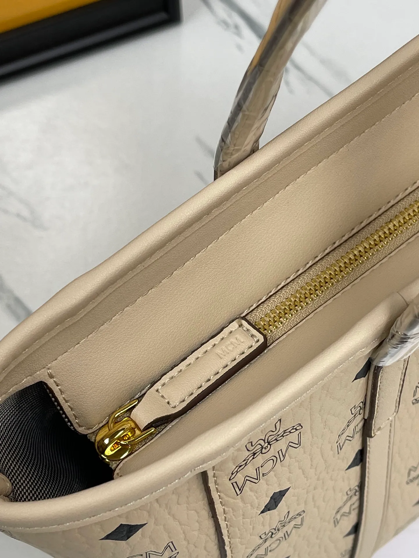 Batch 420💐MCM counter new vegetable basket·Small size [counter synchronization] with gift box🎁Packaging Model 0999 🦁️Toni shopping bag is made of classic Visetos material and decorated with soft Nappa leather trim. The trapezoidal shape combines aesthetic features with strong practicality. Inside, the luxurious cotton canvas compartment is printed with a chain-link pattern inspired by traditional street fashion, and a top zip closure keeps belongings safe. Size: 26*25 cm,