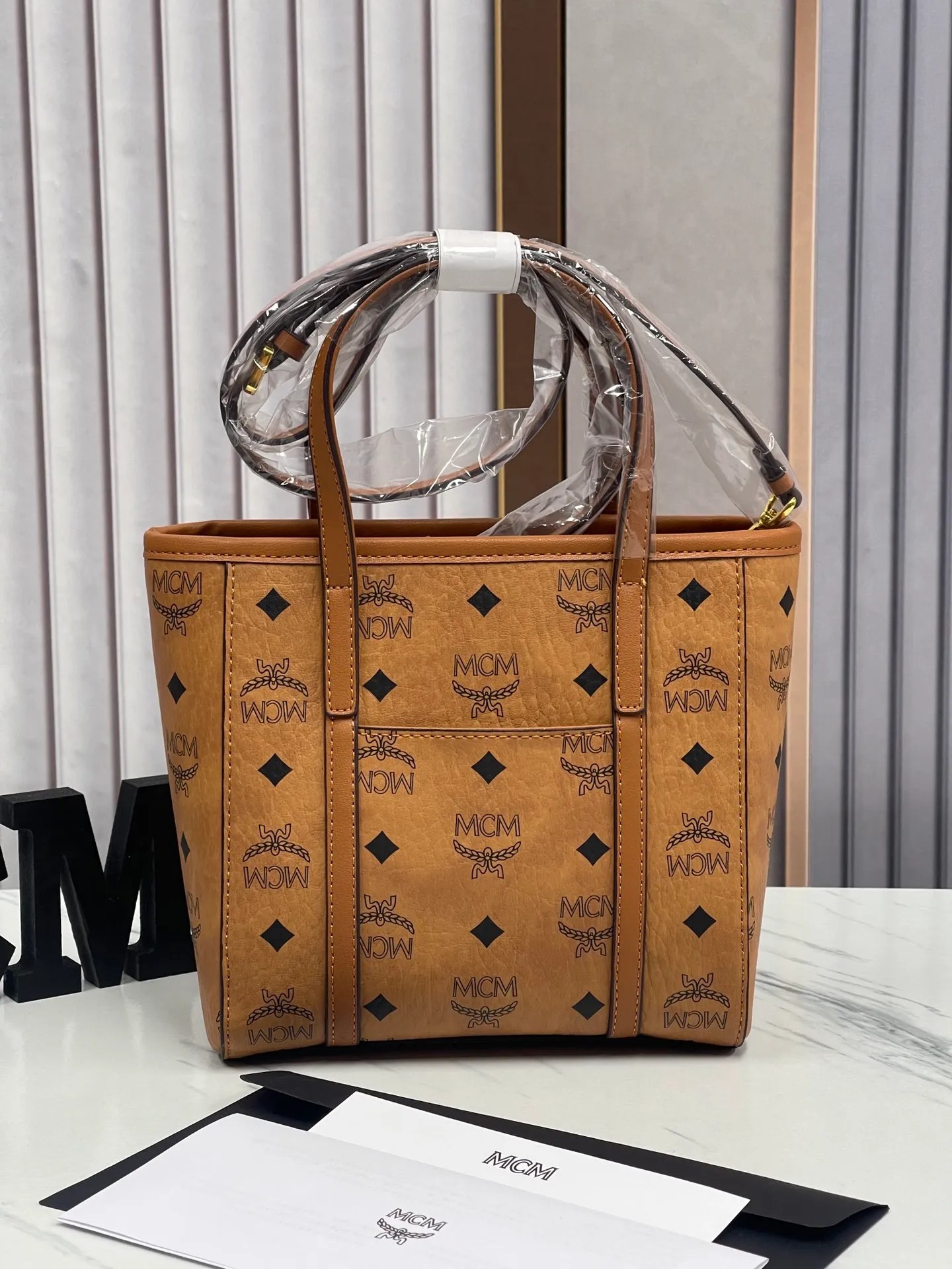 Batch 360💰🎋MCM new upgraded version·High quality✈️ Comes with environmentally friendly gift box♻️🎁Packaging model: 190820 Toni Visetos shopping bag has a new look, super beautiful👗 This compact shopping bag is multi-functional and will last forever. Don't let the size of this mini tote fool you, it's designed with spacious interior and exterior compartments to store all your small essentials. The cotton canvas lining features a print inspired by street fashion, subtly retaining MCM's adventurous aesthetic. Pair it with the included cross-body strap for hands-free functionality and greater portability. 18.5x19x9.5cm🌸